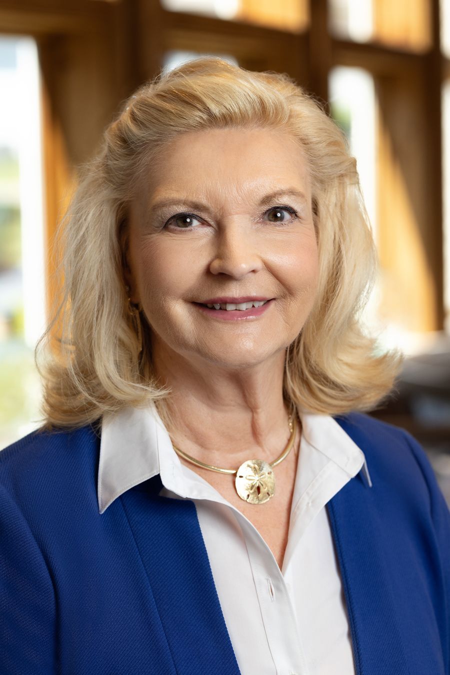 A woman in a red jacket and black shirt is smiling for the camera.