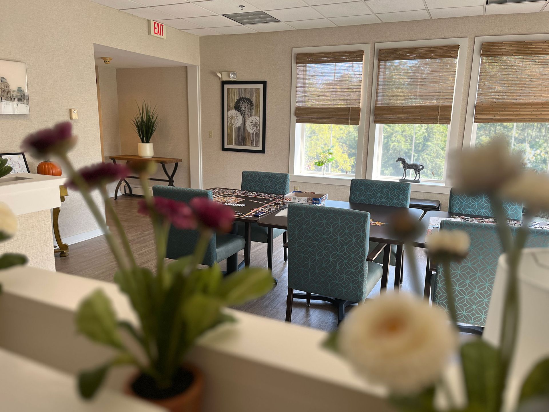 A woman is holding a laptop next to senior man on an exercise bike