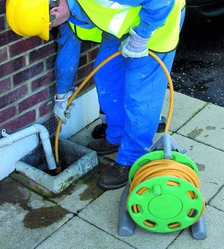 A expert cleaning a domestic drain