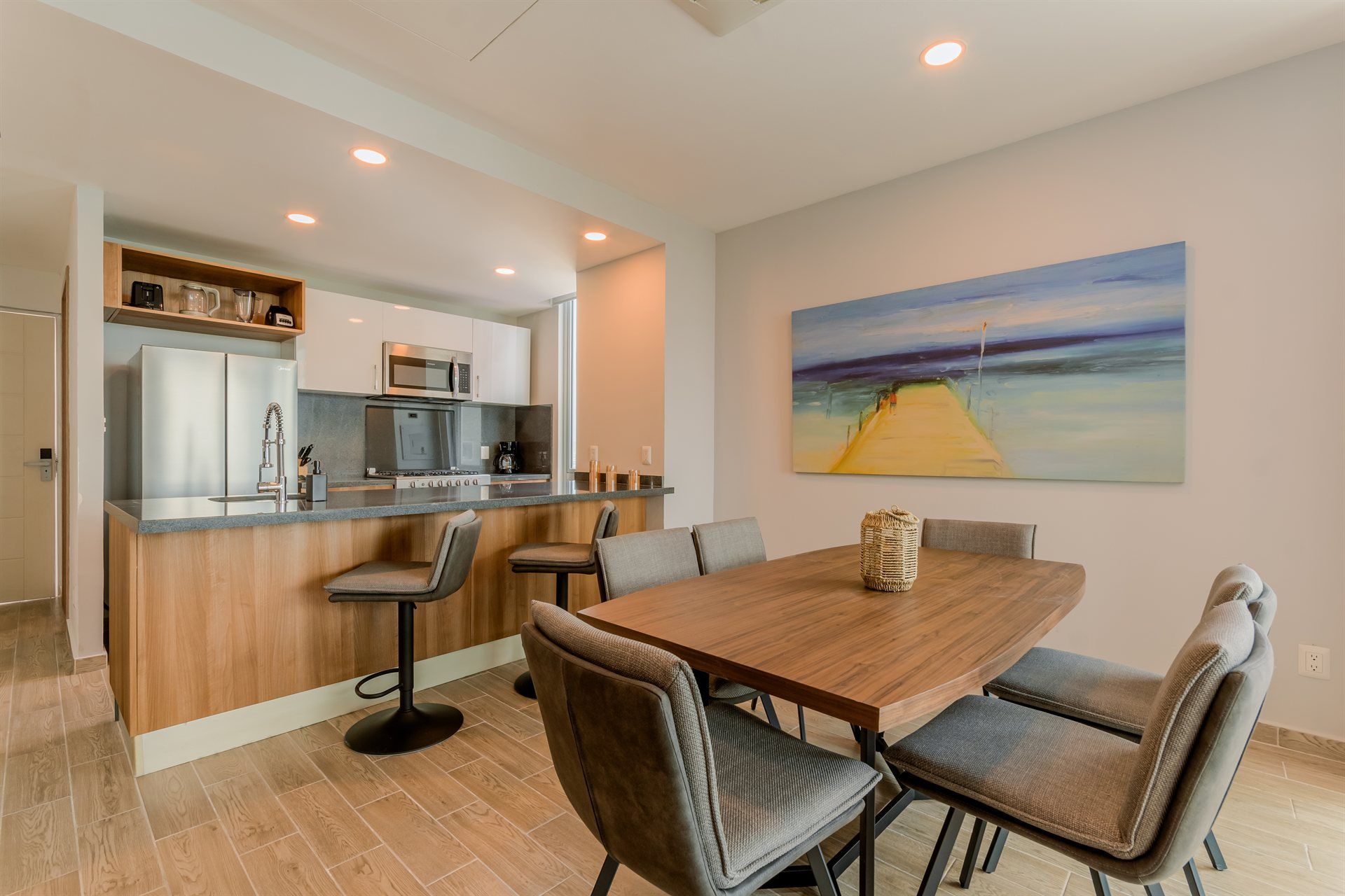 Un comedor con una mesa y sillas y un cuadro en la pared.