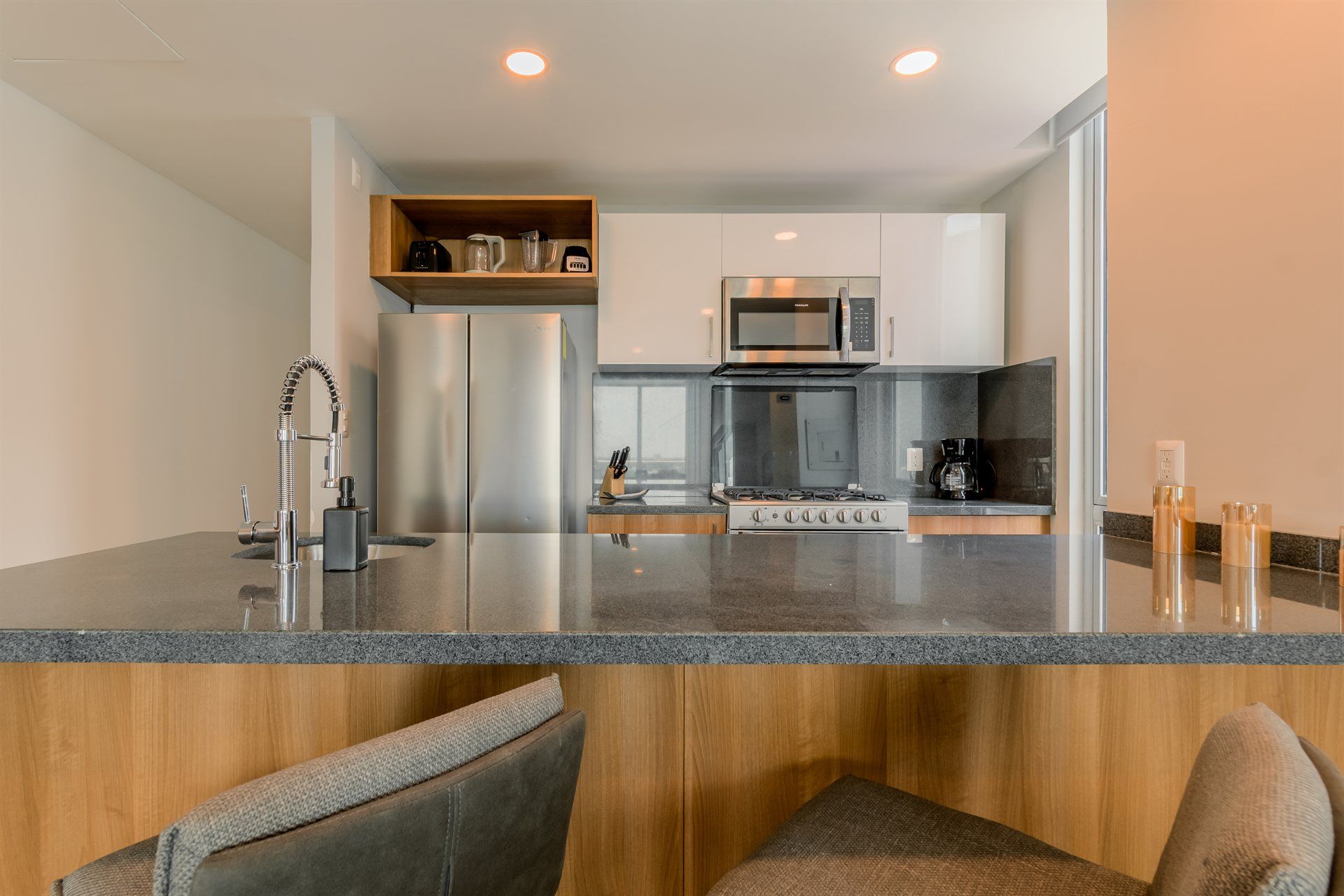 Una cocina con estufa, refrigerador, microondas y fregadero.