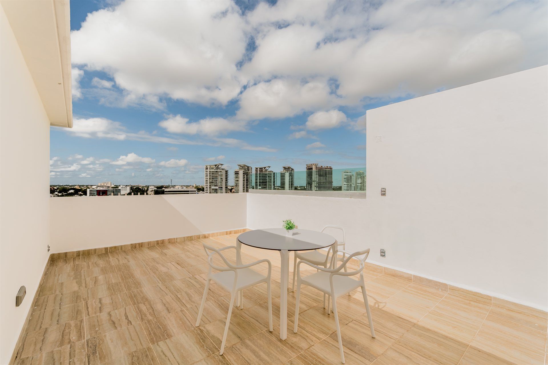 Un balcón con mesa y sillas y vista a la ciudad.