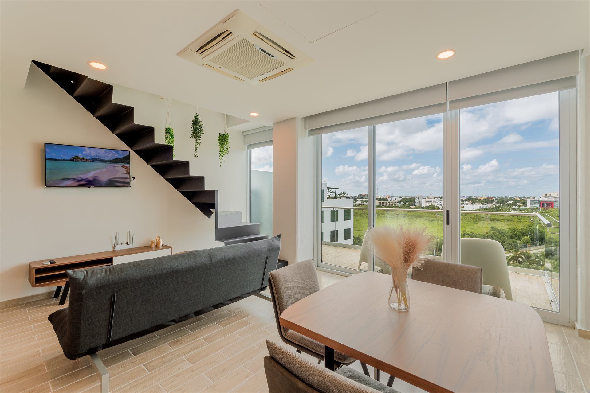 Una sala de estar con sofá, mesa, sillas y escaleras.