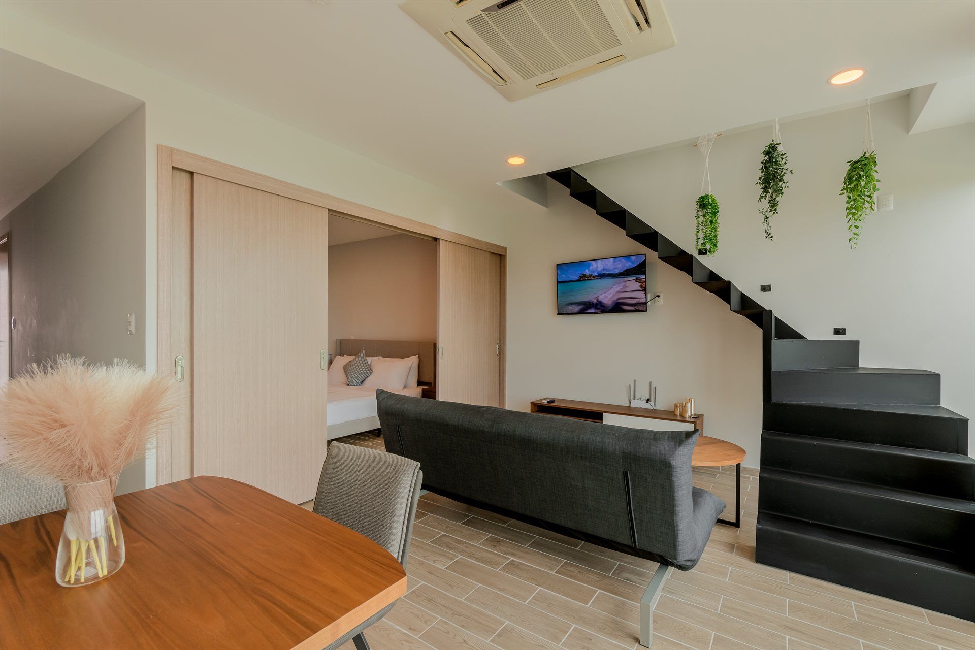 Una sala de estar con sofá, mesa, sillas y escaleras.