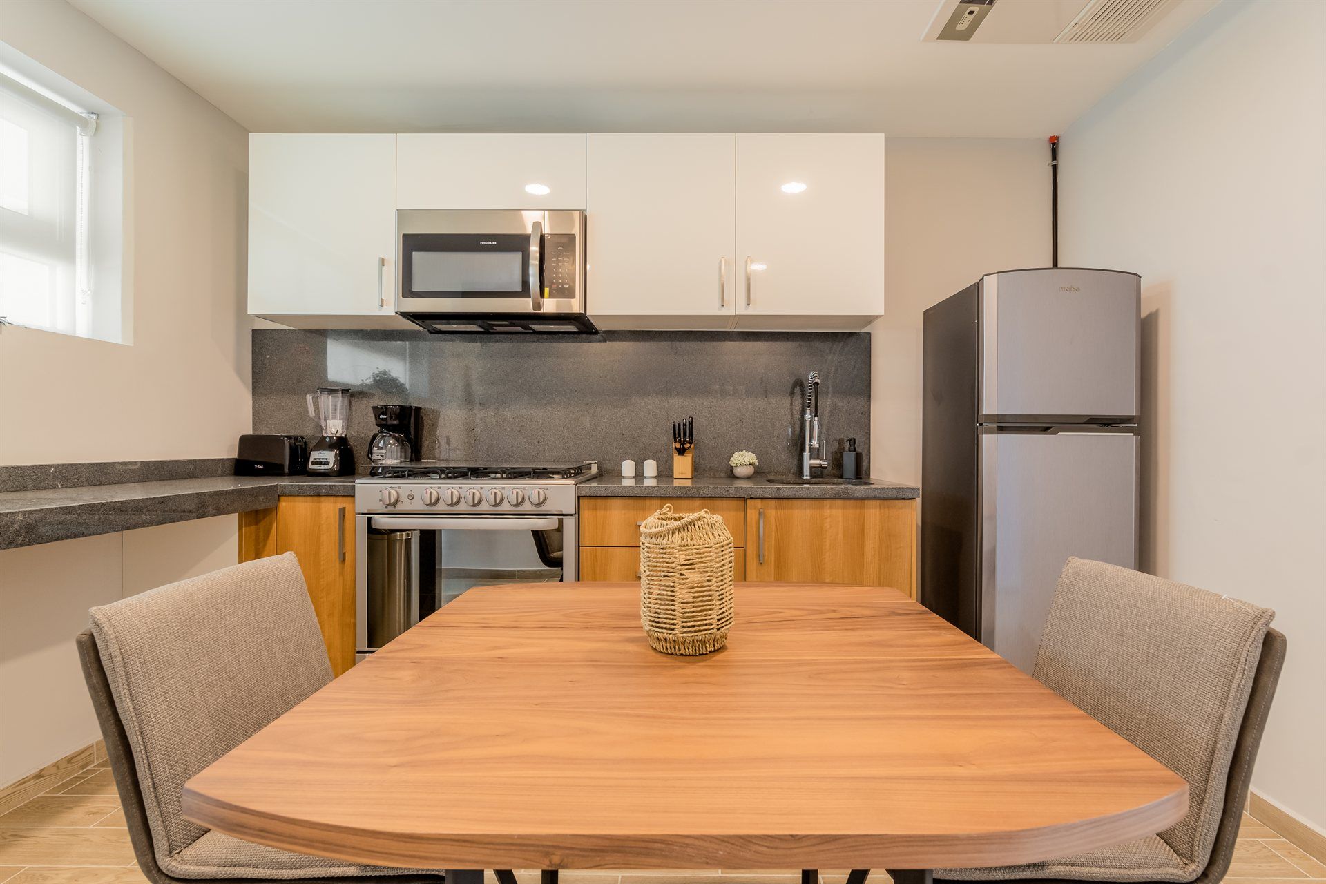 Una cocina con mesa y sillas y un frigorífico.