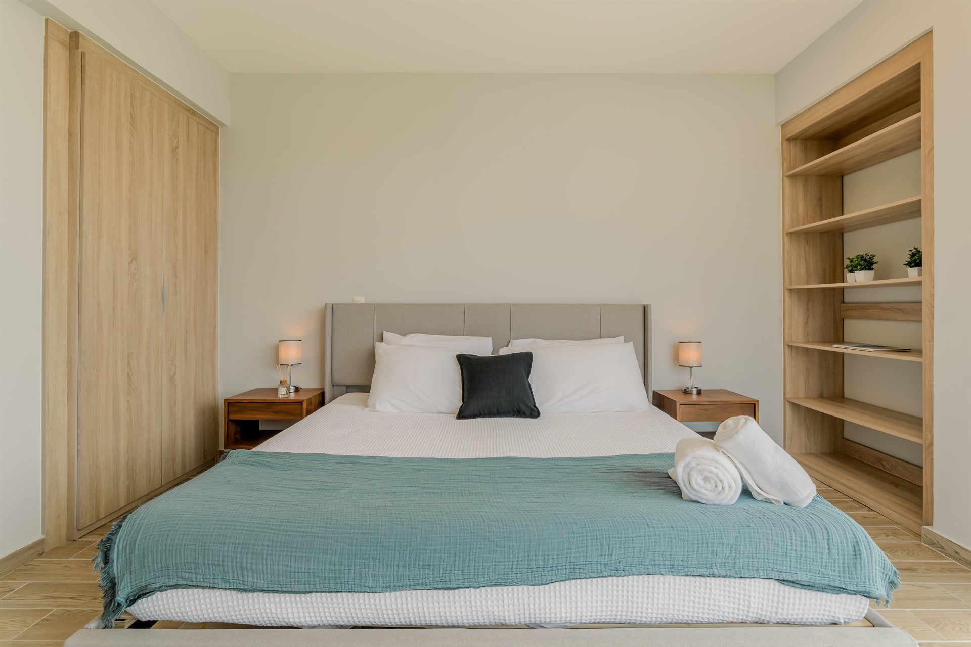 Un dormitorio con una cama king size y una estantería.