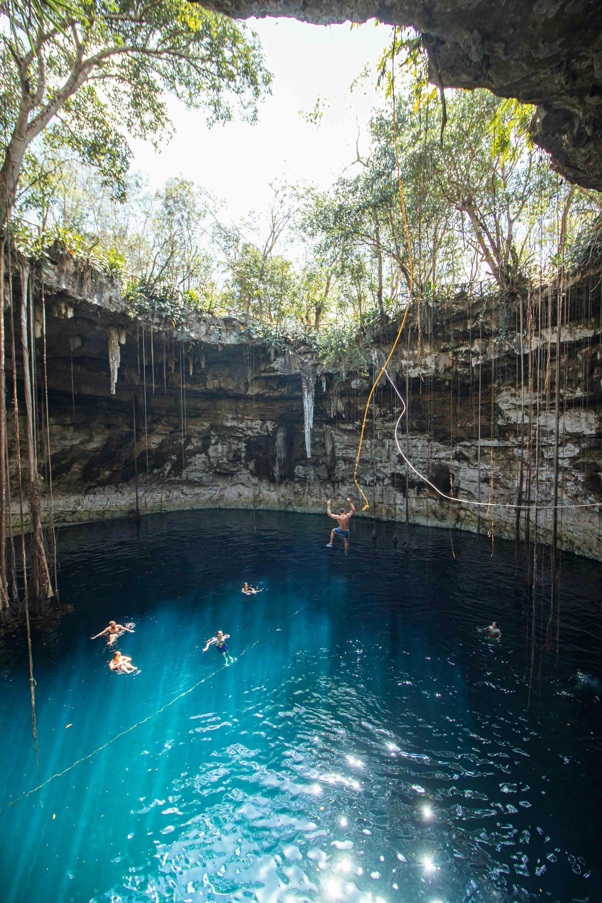 Un grupo de personas está nadando en un cenote