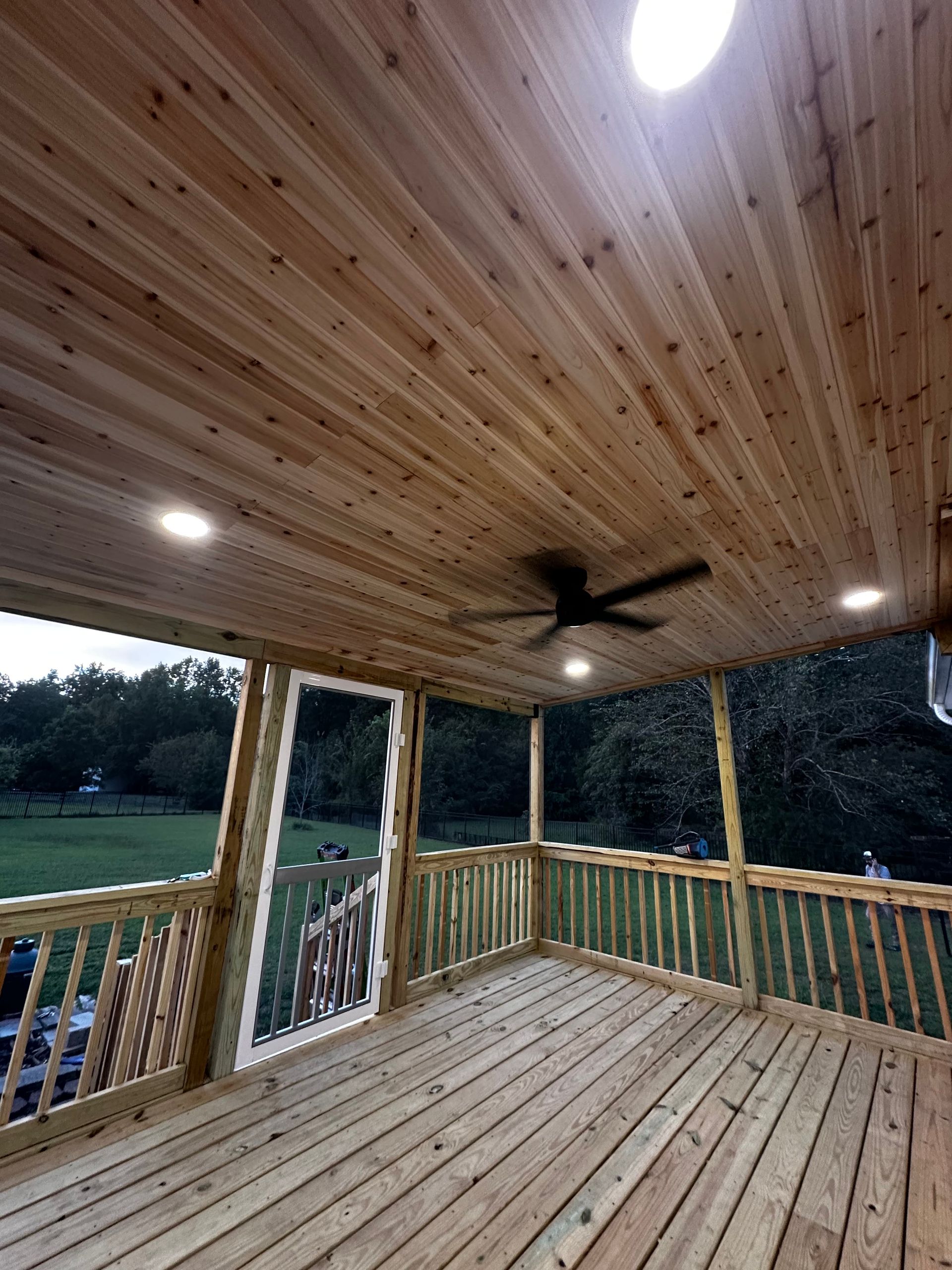 Wooden deck with a matching ceiling, recessed lights, and a ceiling fan.