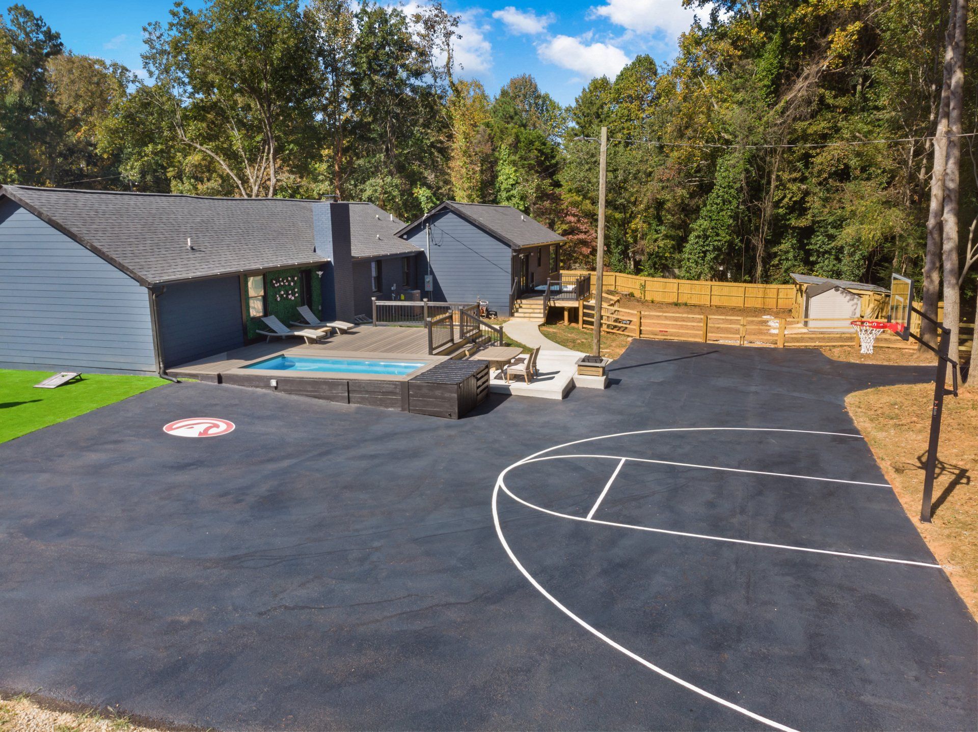 An aerial view of a basketball court in front of a house