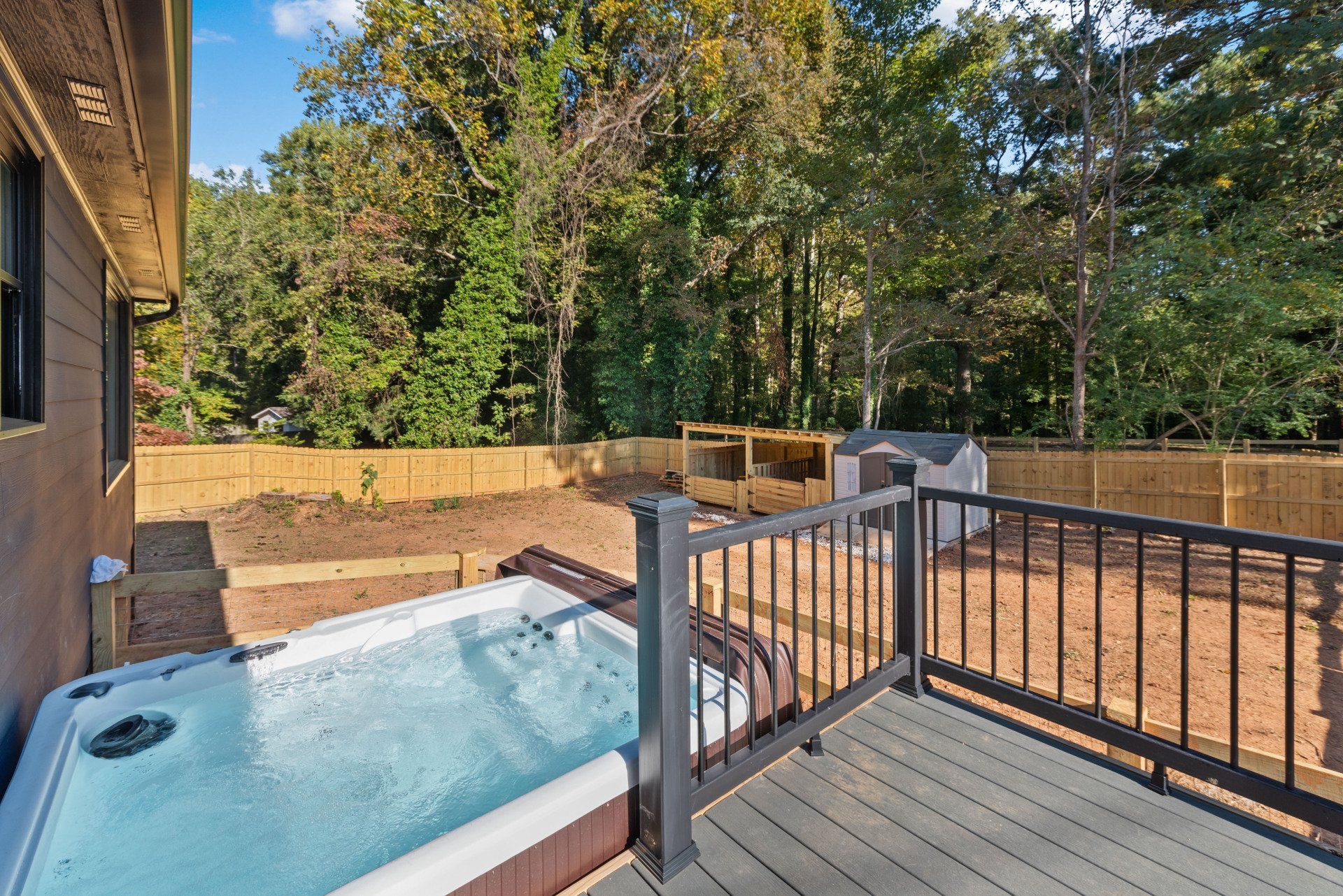 There is a hot tub on the deck of a house.