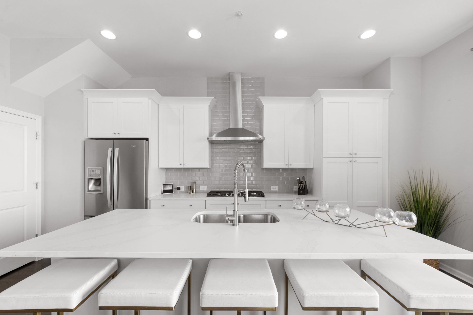 A kitchen with white cabinets and a stainless steel refrigerator