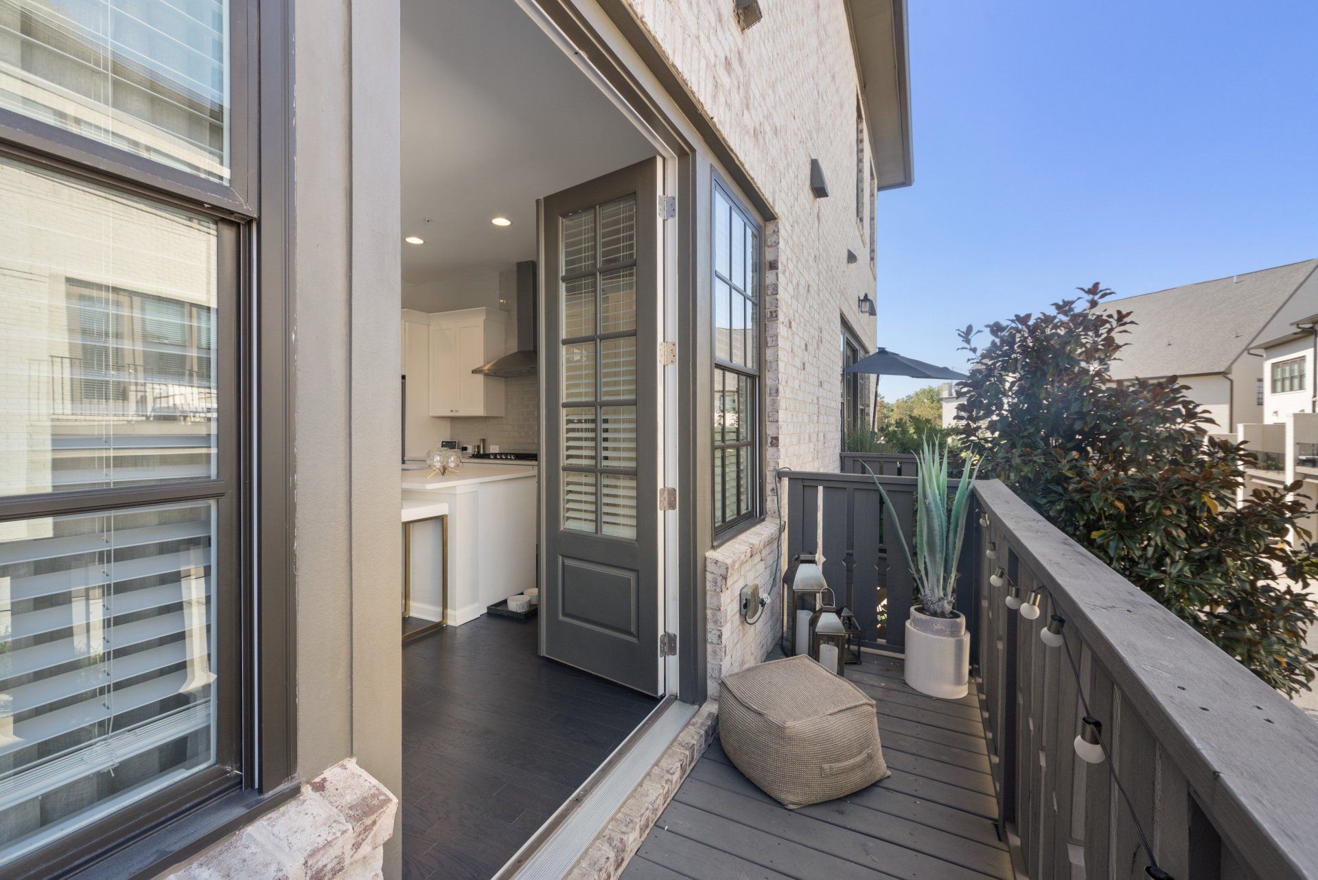 A balcony with a sliding glass door leading to a kitchen.