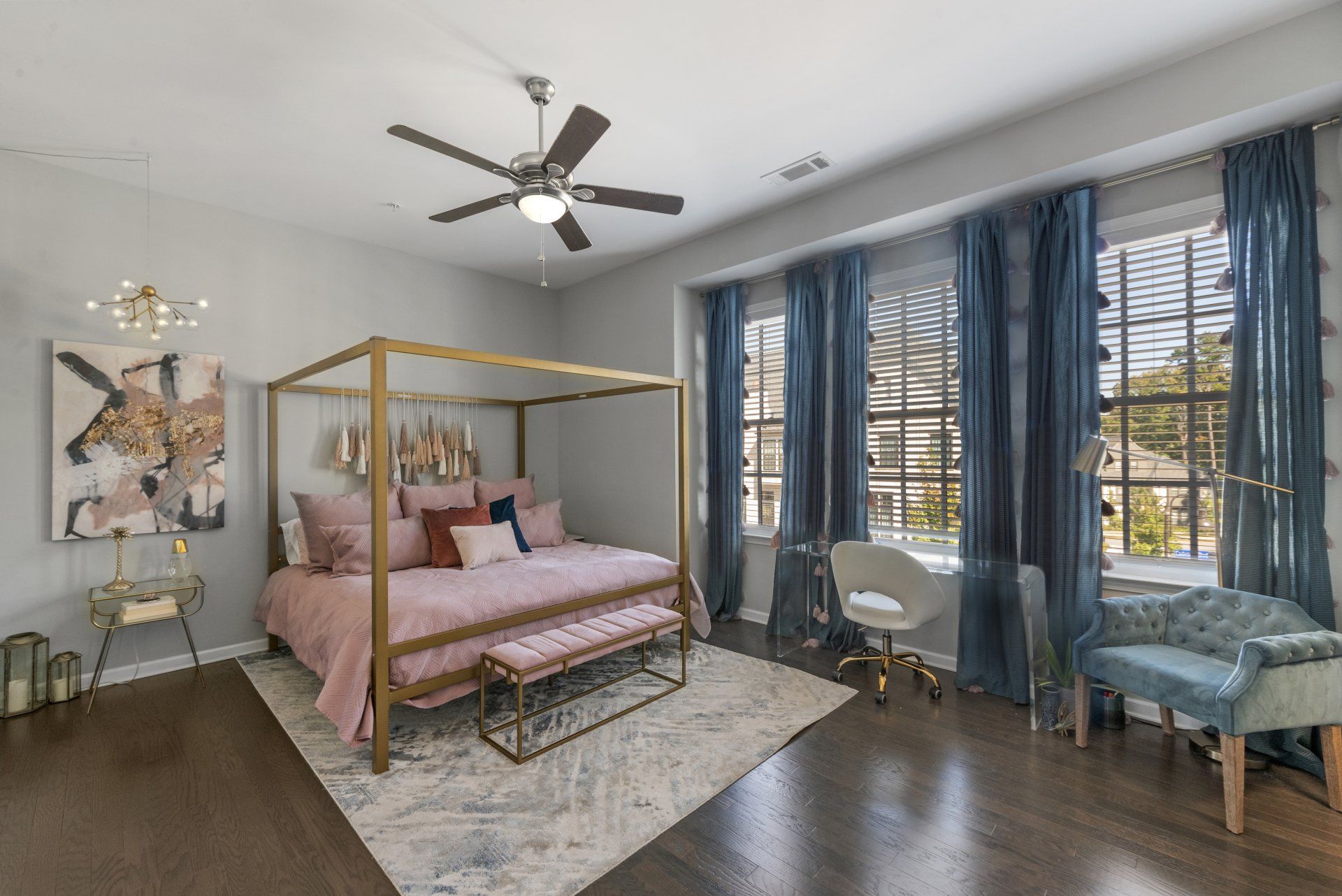 A bedroom with a canopy bed and a ceiling fan.