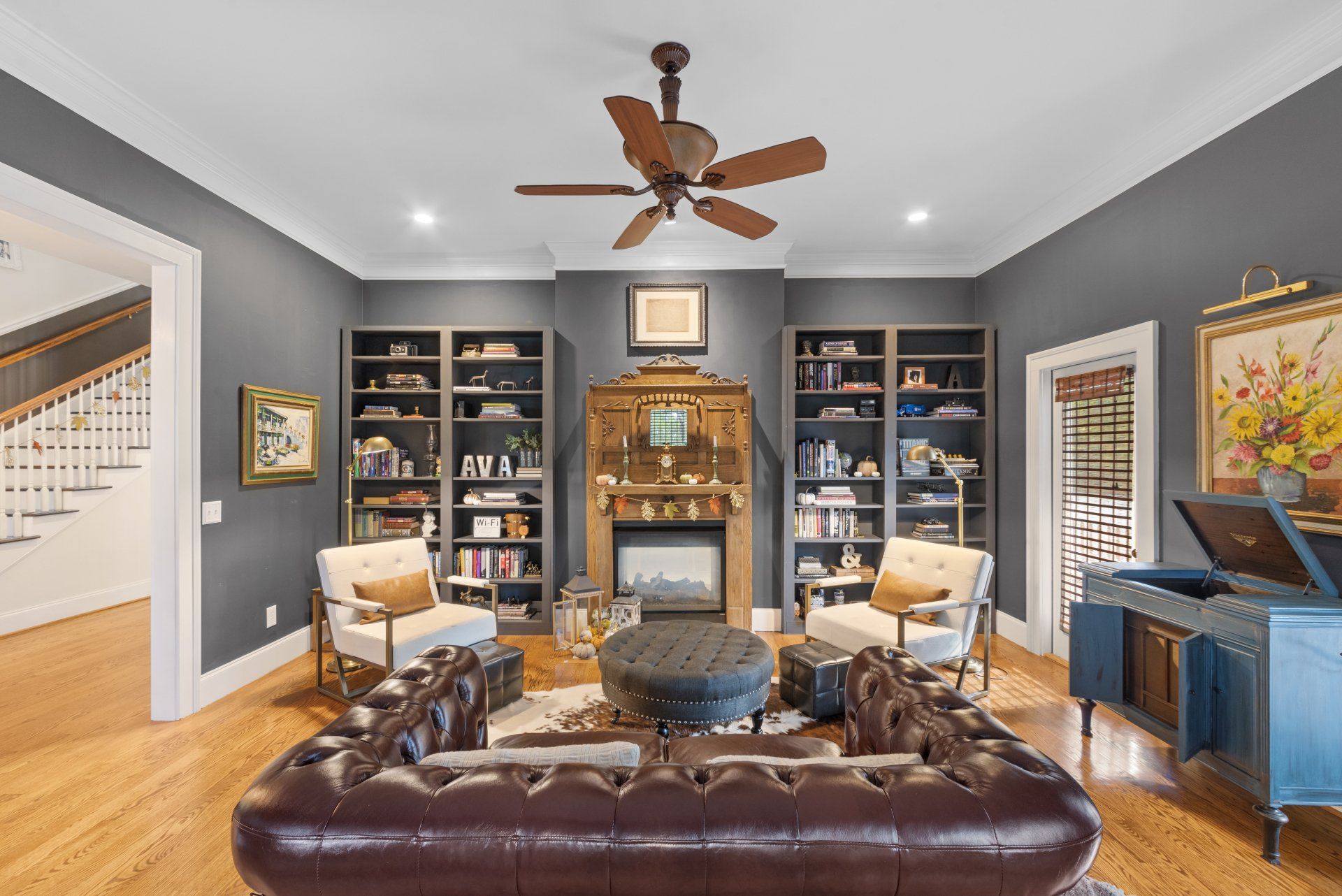 A living room with a fireplace and a ceiling fan.