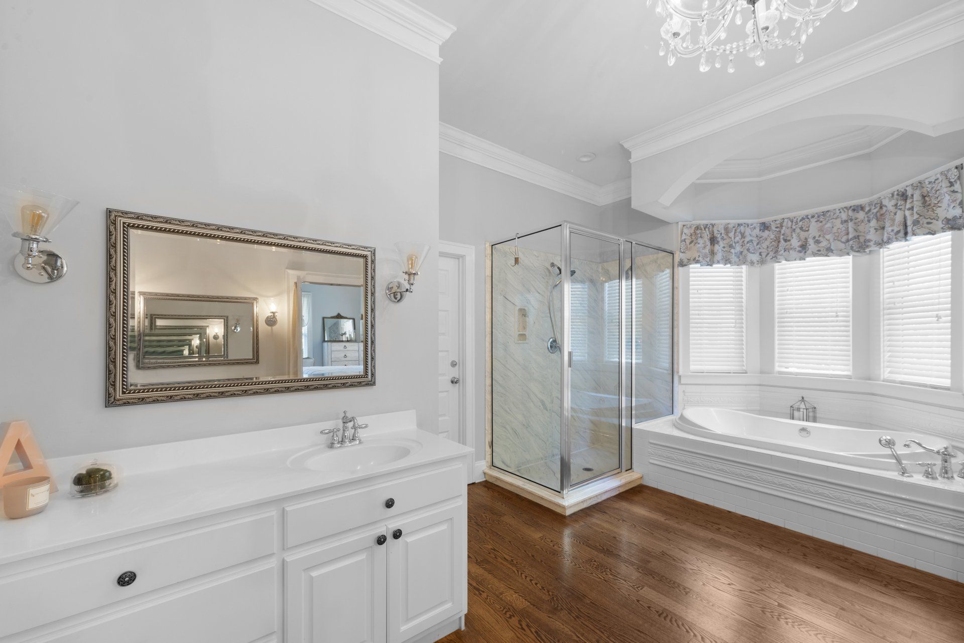 A bathroom with a tub , sink , mirror and shower.