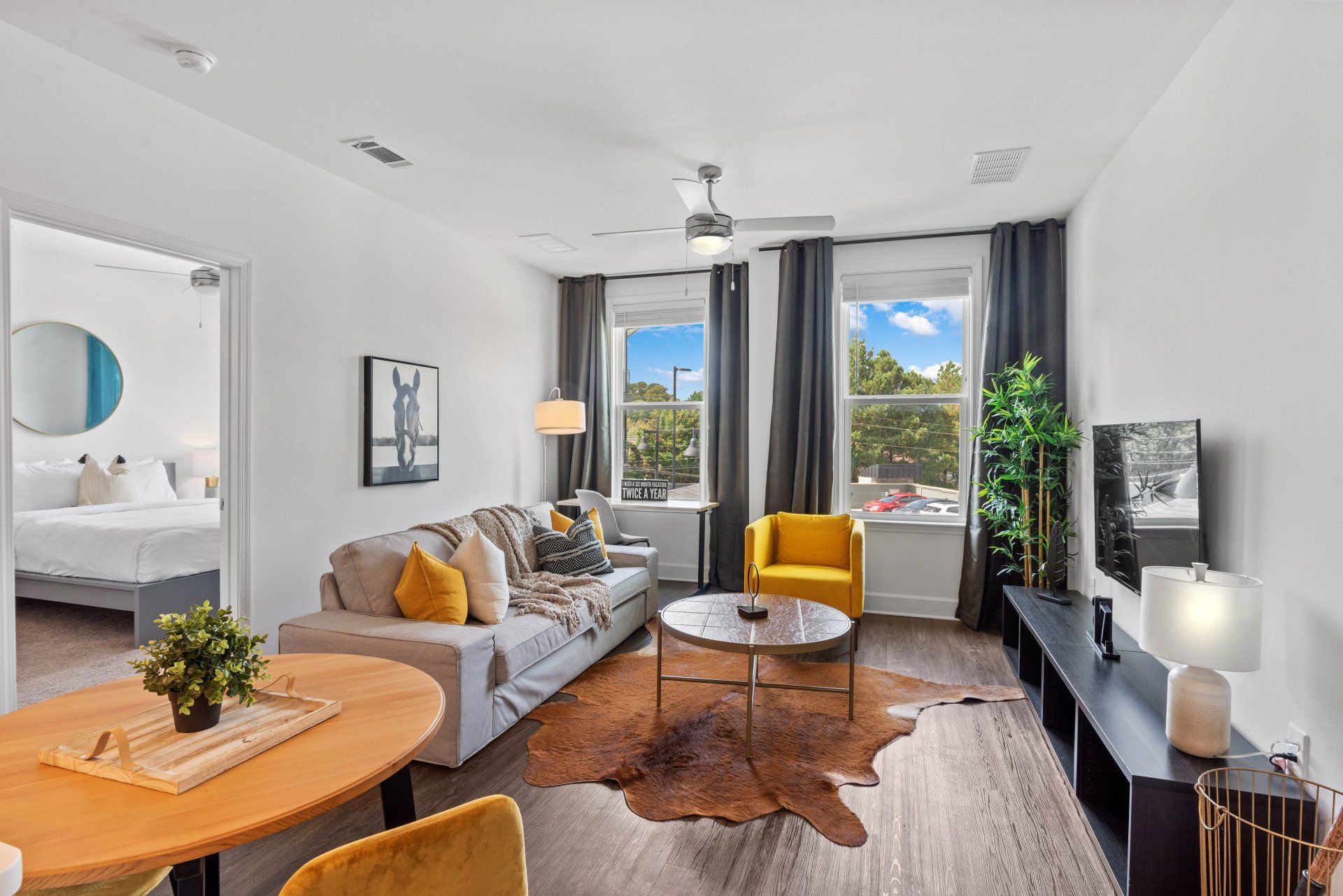 A living room with a couch , chair , table and television.
