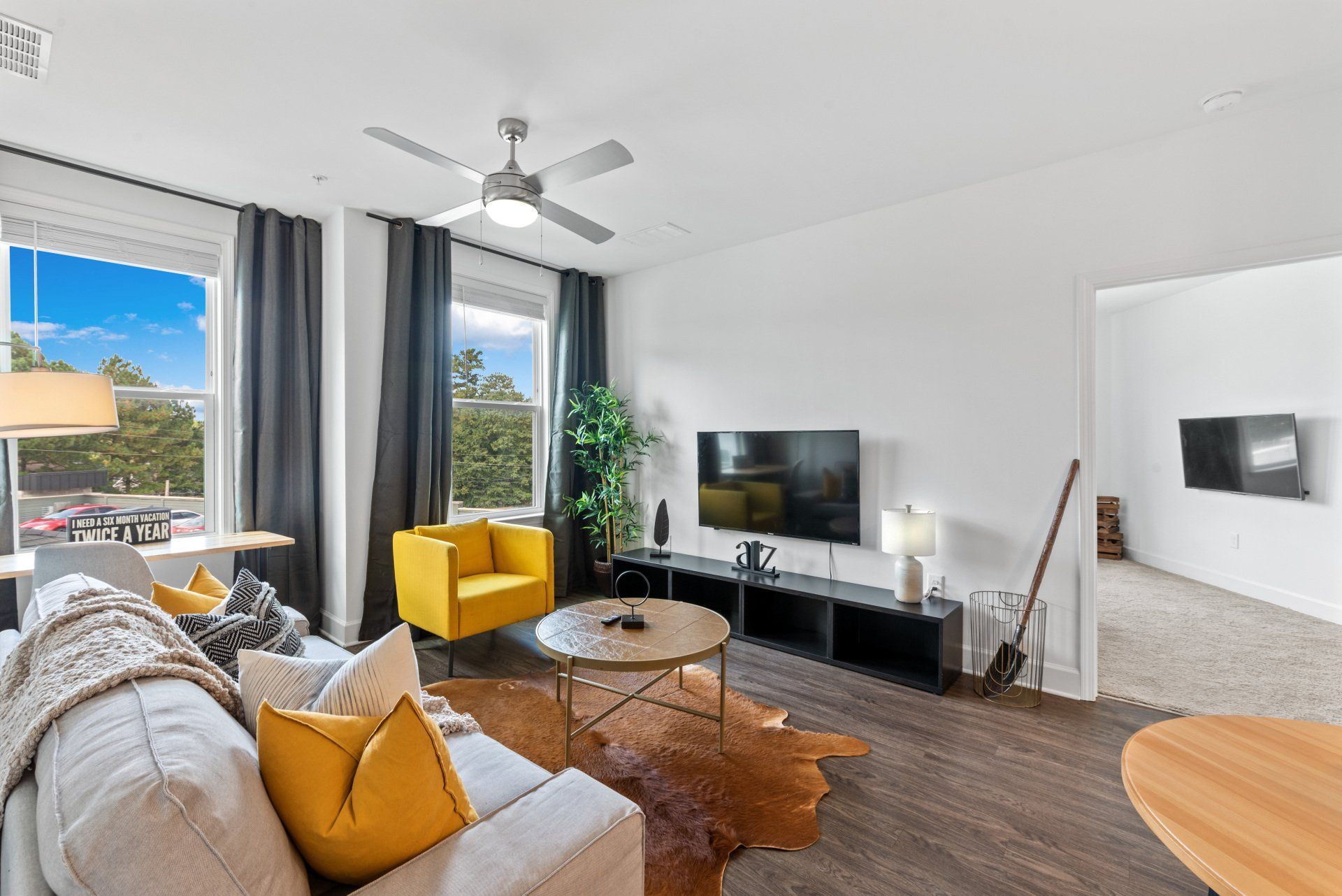 A living room with a couch , chair , table and television.