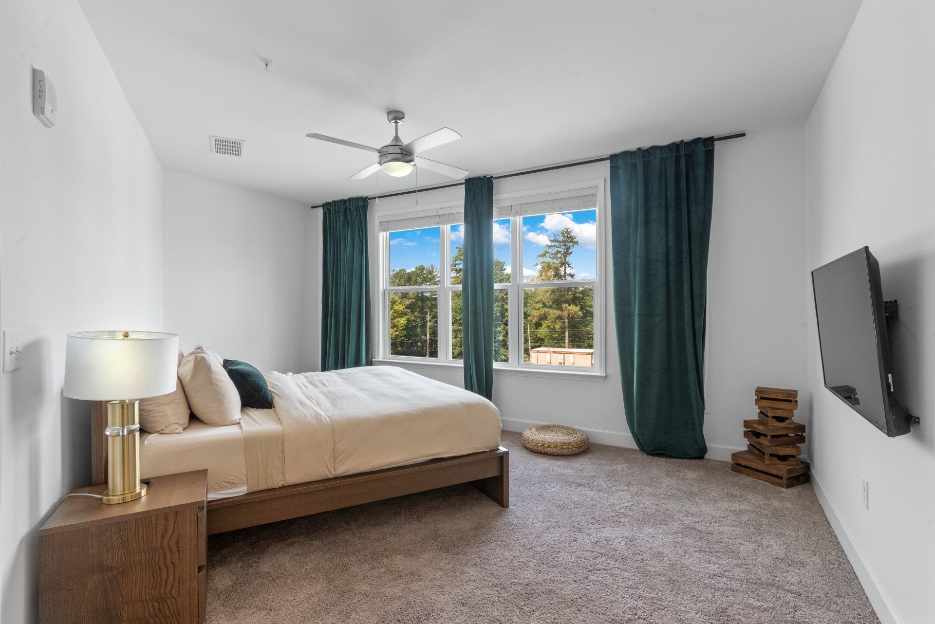 A bedroom with a large bed and a flat screen tv on the wall.
