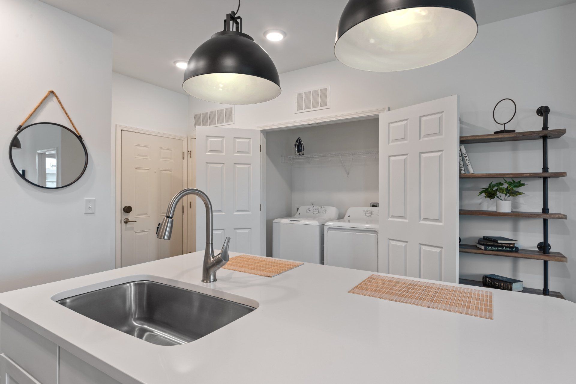 A kitchen with a sink and a washer and dryer in the background.