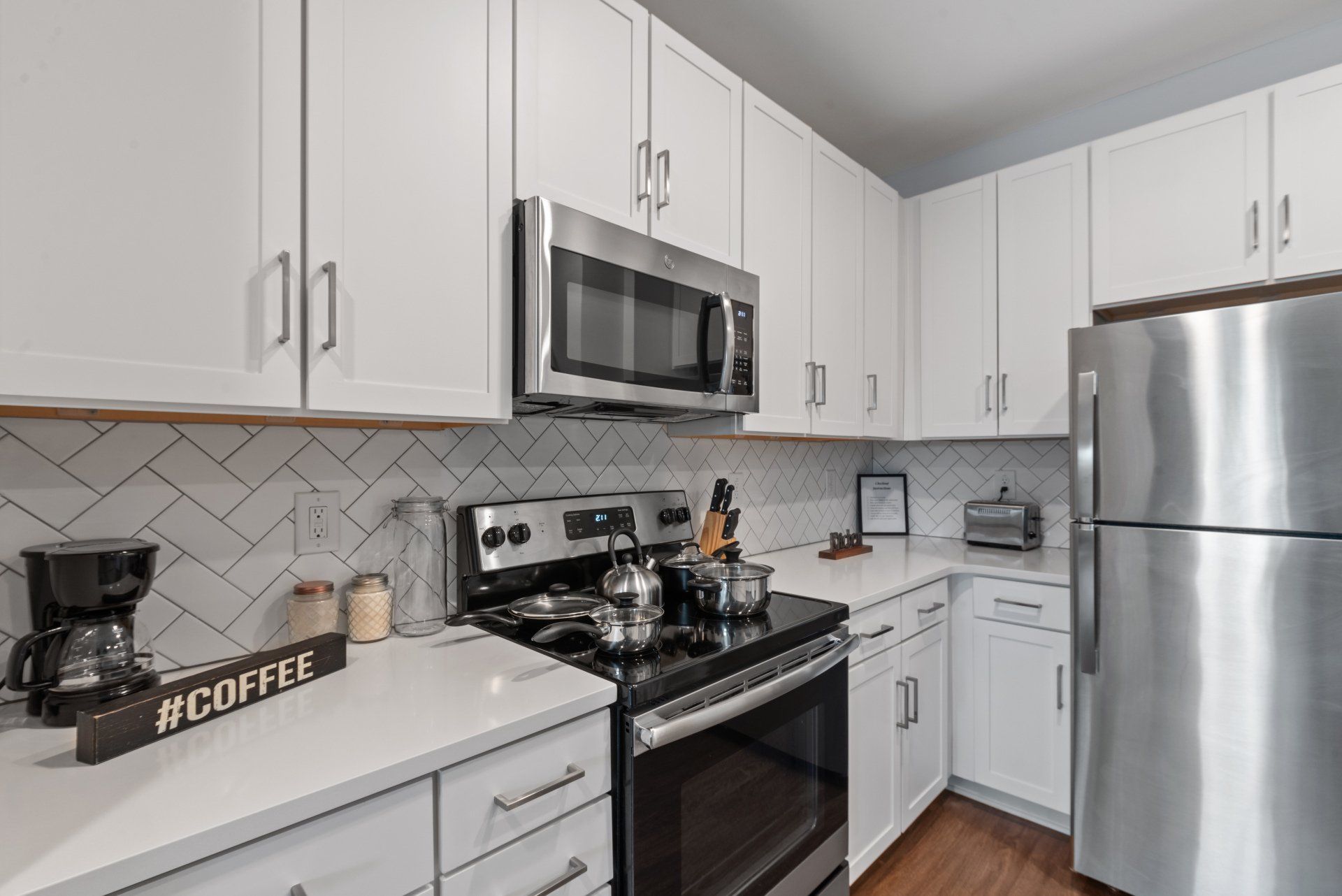 A kitchen with stainless steel appliances and white cabinets