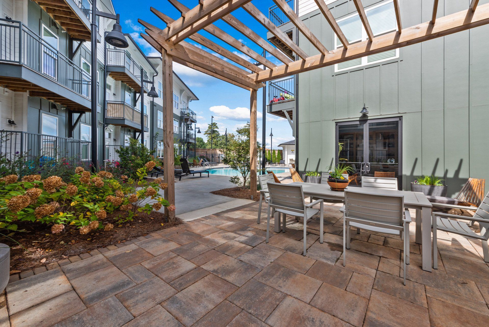 A patio with a table and chairs under a pergola.