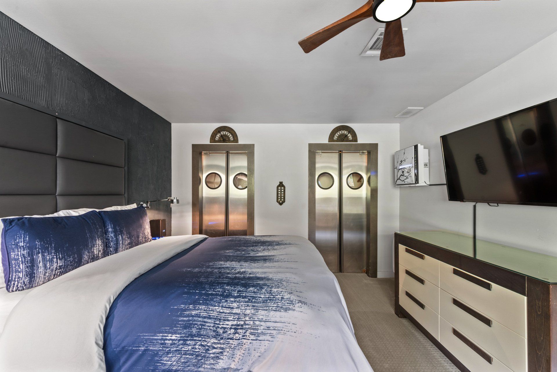 A hotel room with a king size bed and a flat screen tv.