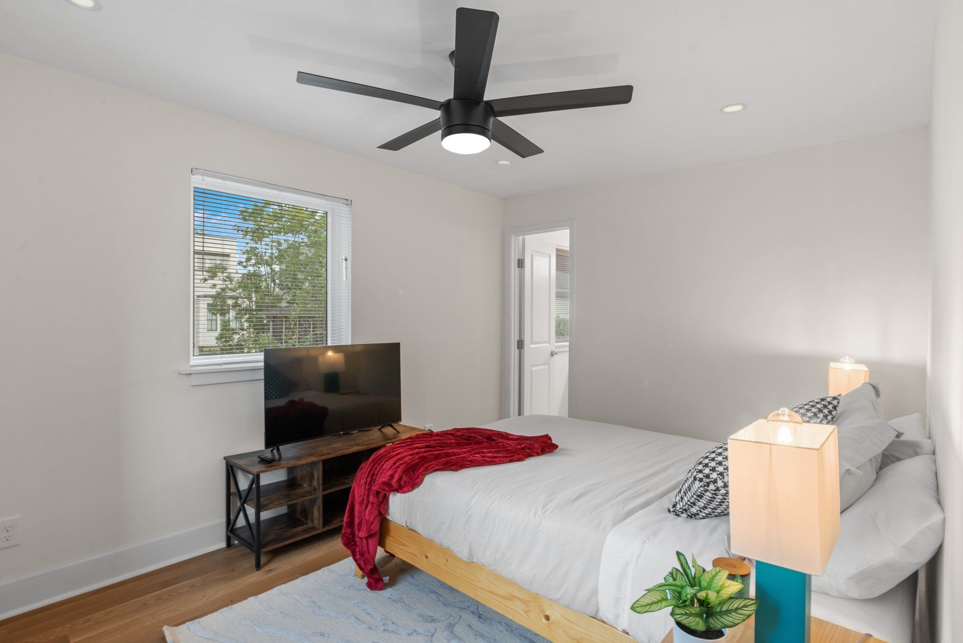 A bedroom with a bed , television and ceiling fan.