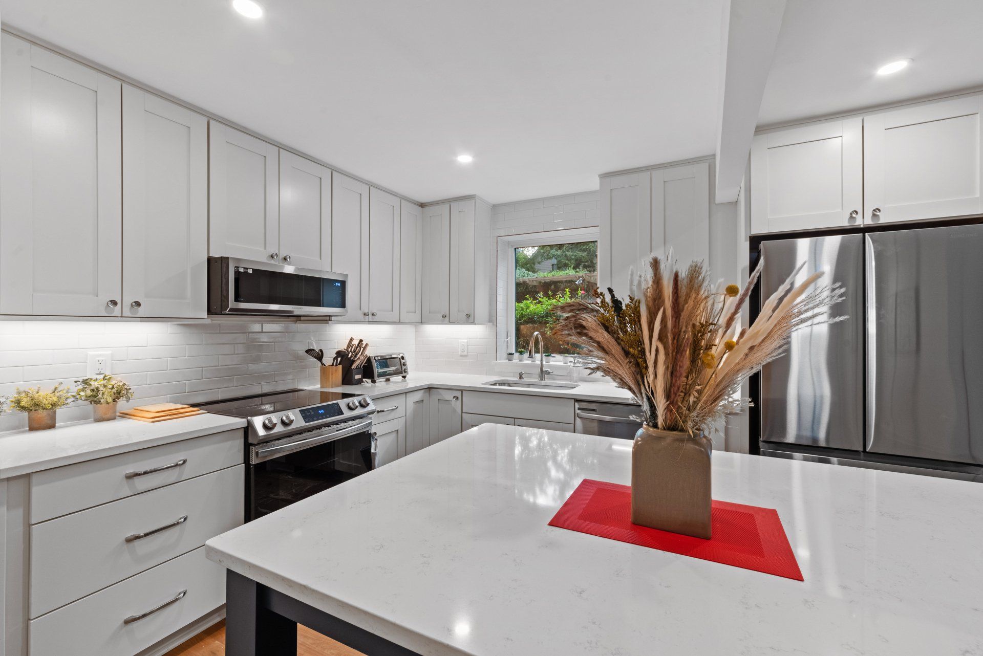 A kitchen with white cabinets and stainless steel appliances