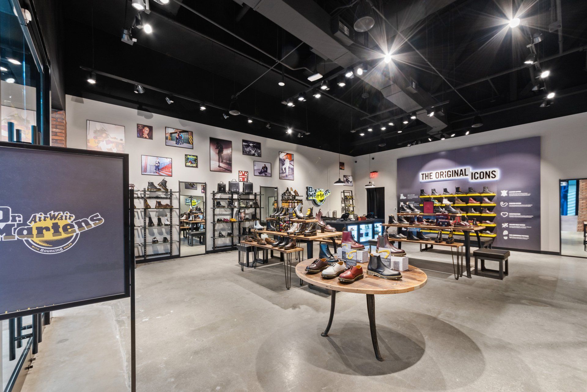 The inside of a shoe store with tables and shelves.