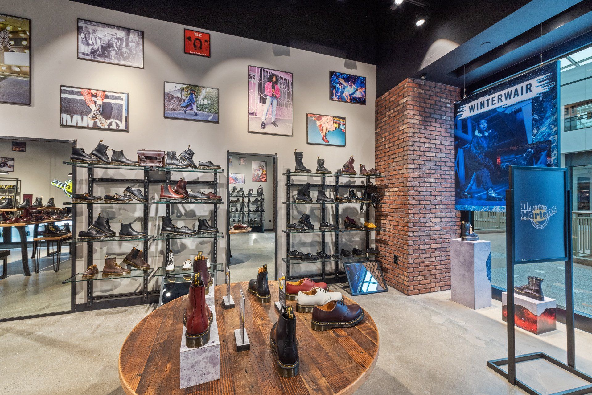 A store filled with lots of shoes and a round table.