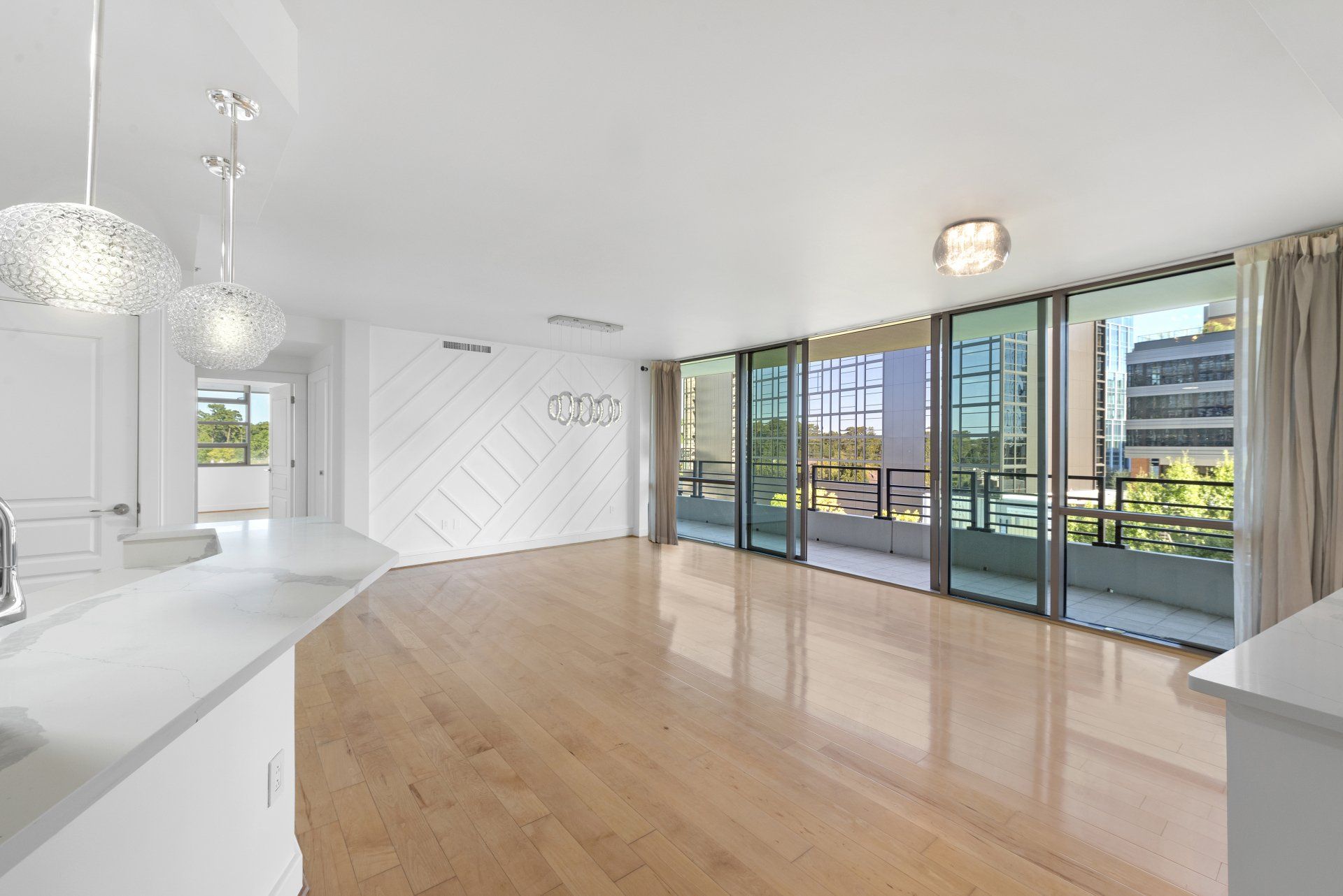 An empty apartment with hardwood floors and sliding glass doors