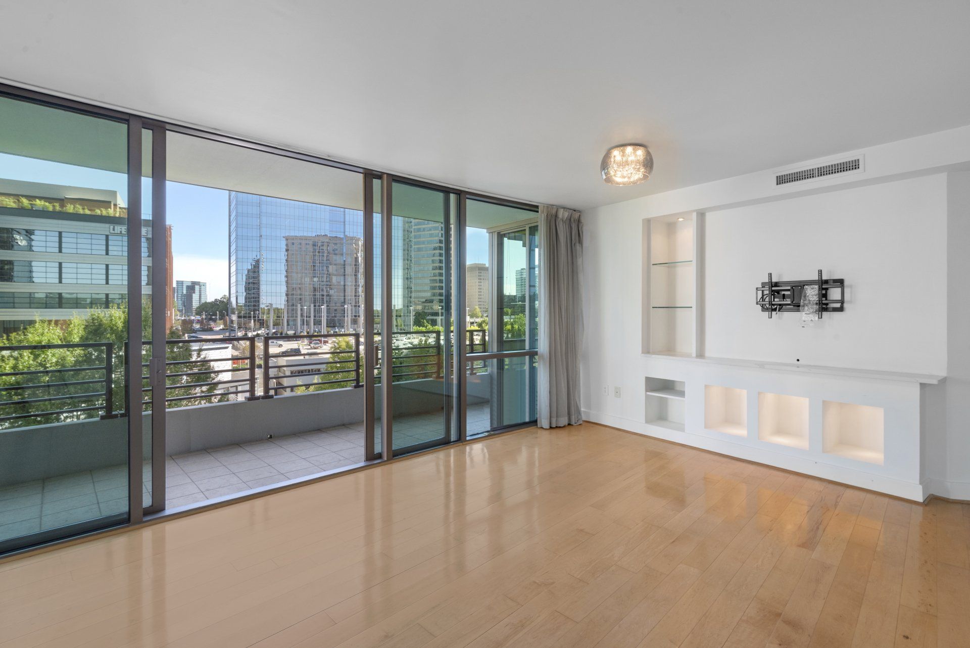 An empty living room with sliding glass doors and a balcony