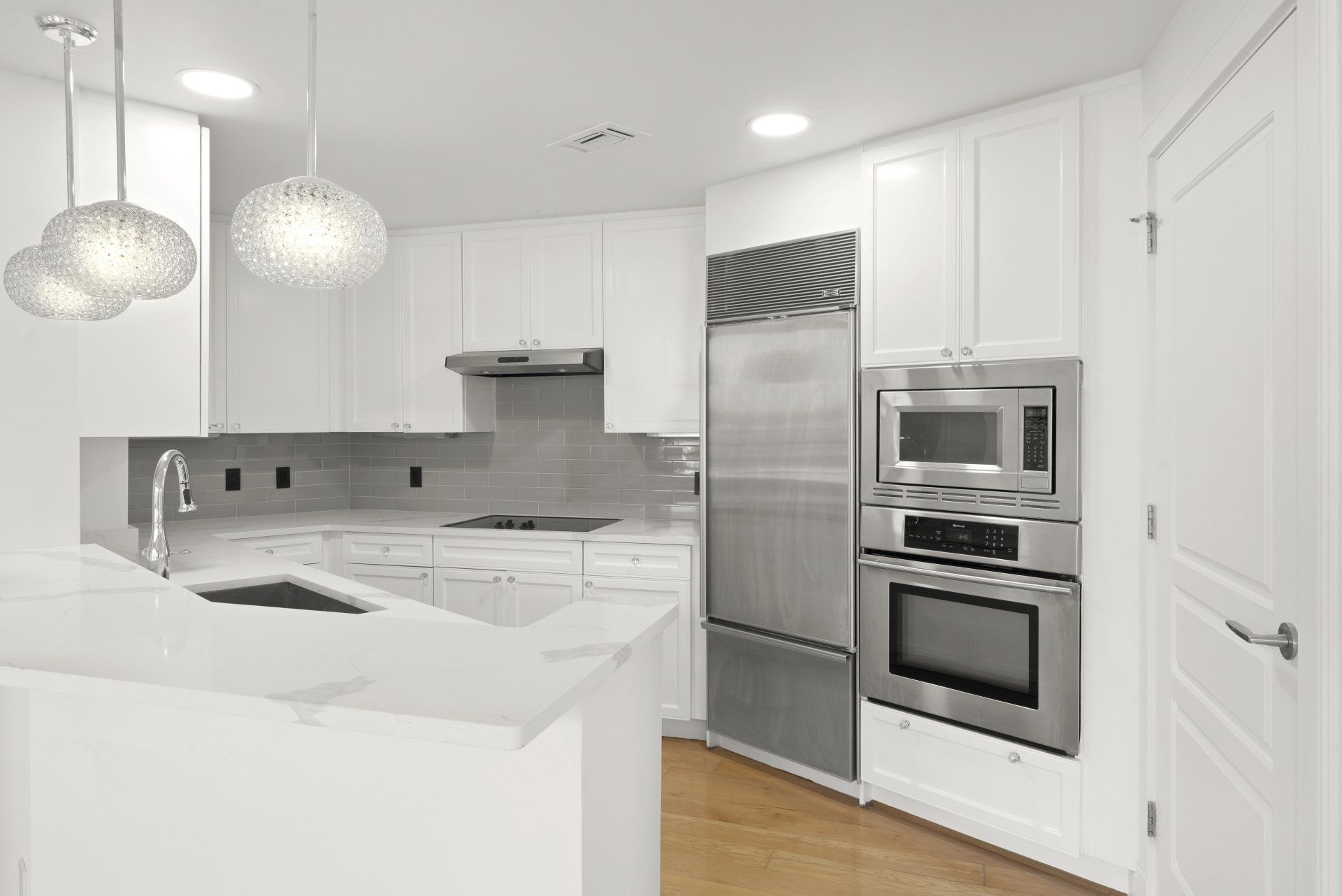 A kitchen with white cabinets and stainless steel appliances