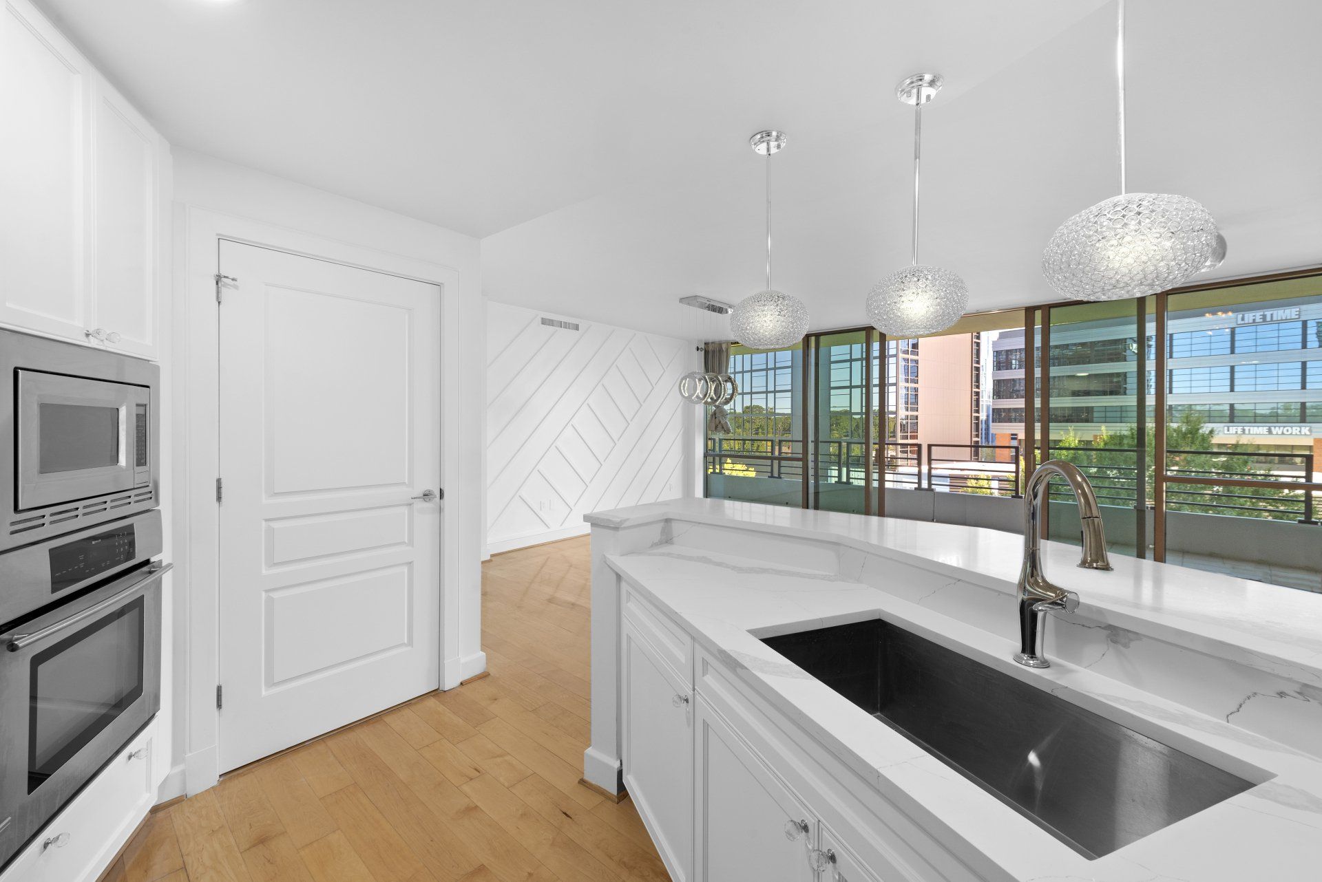 A kitchen with white cabinets and a stainless steel sink