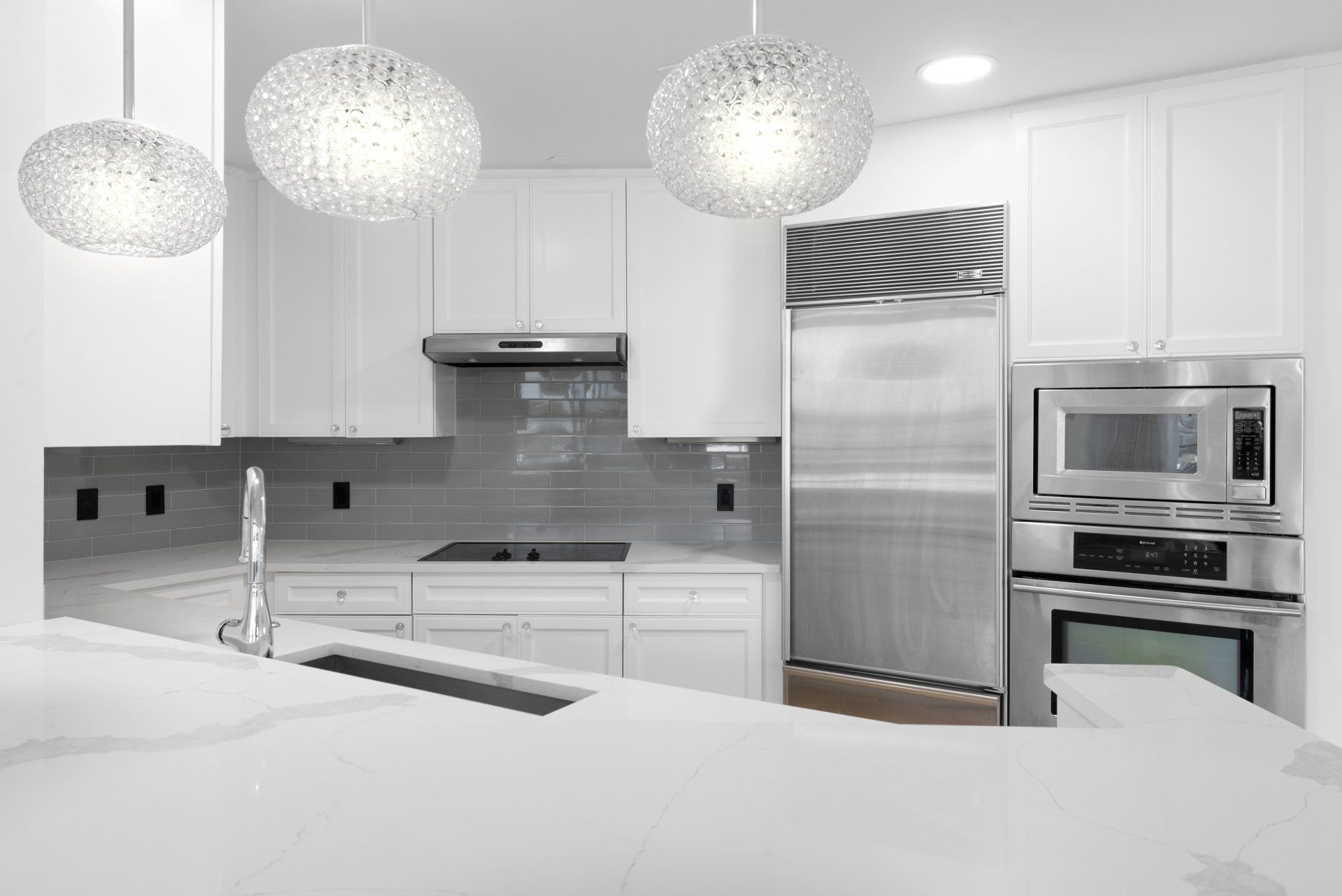 A kitchen with white cabinets and stainless steel appliances.