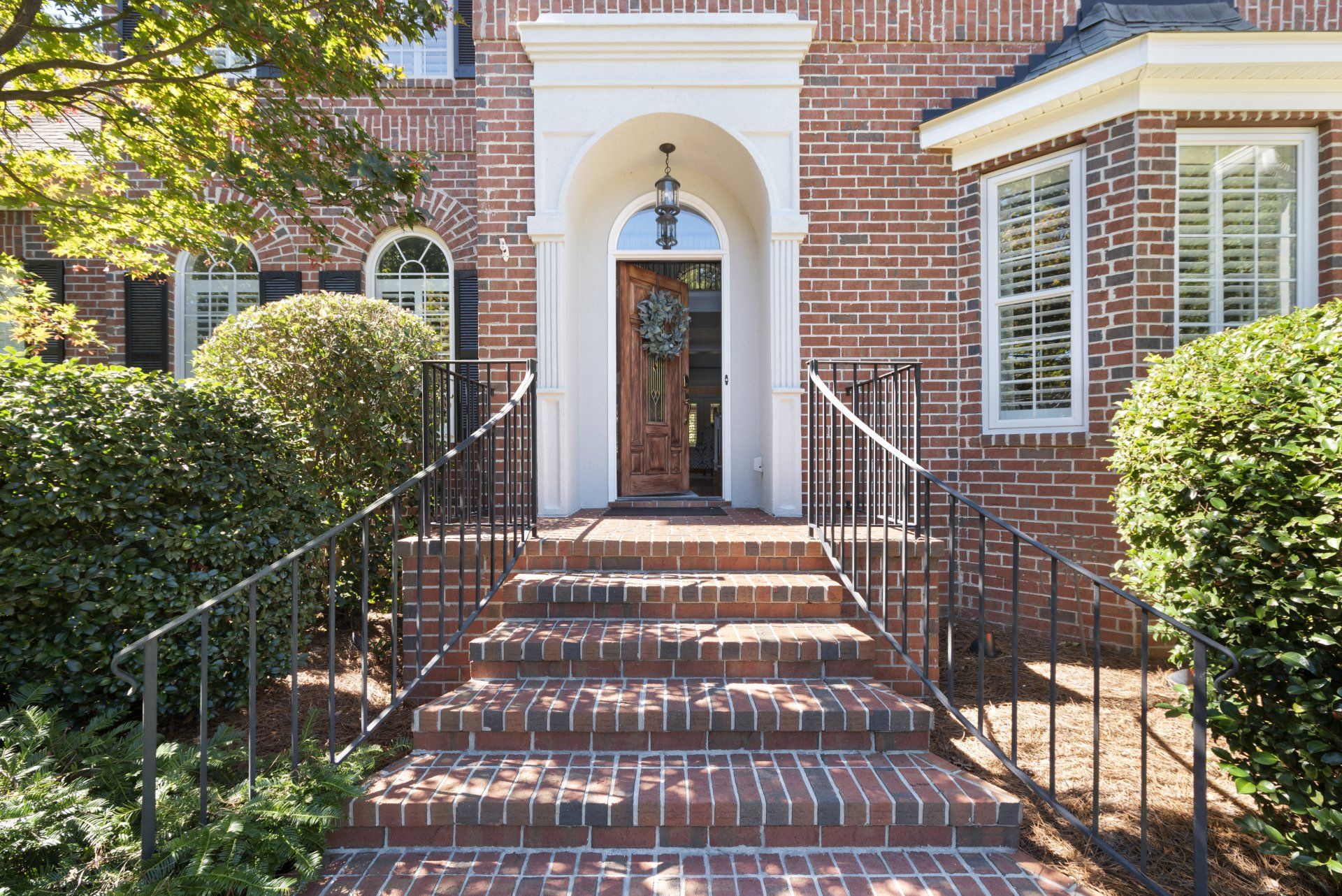 A brick house with stairs leading up to the front door