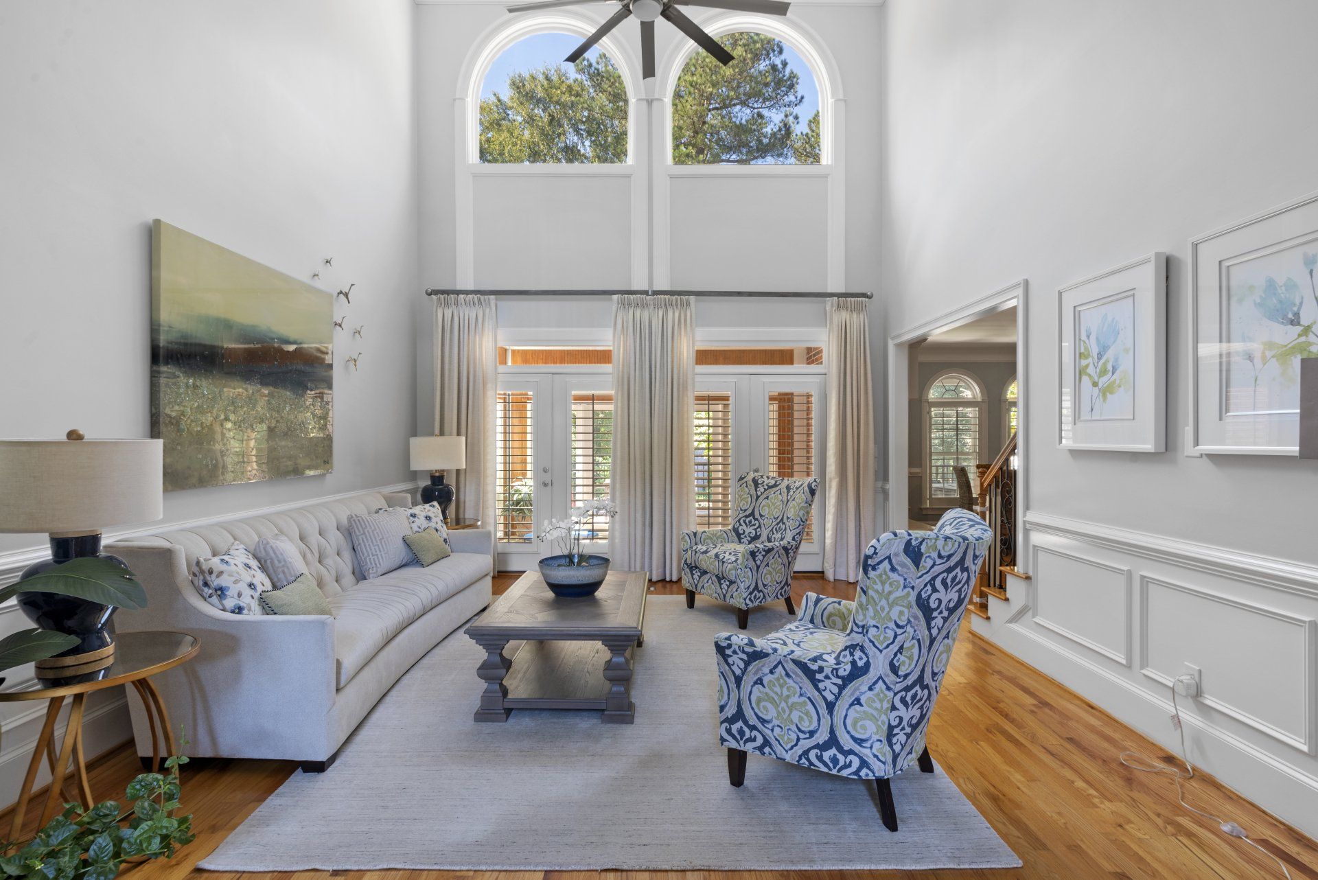 A living room with a white couch and blue chairs