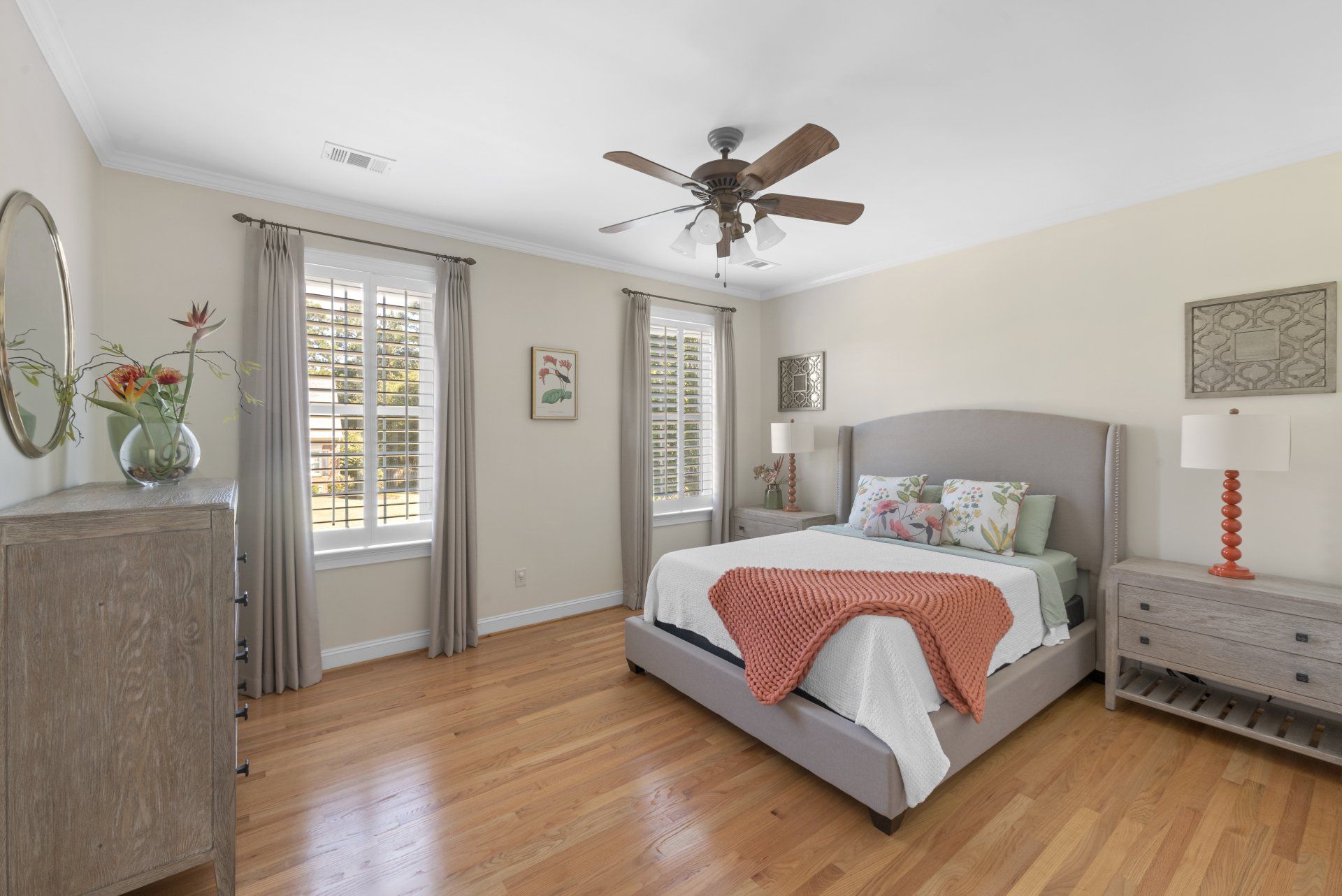 A bedroom with a large bed and a ceiling fan