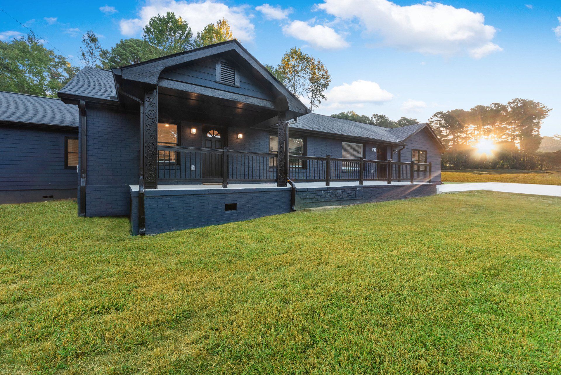 A black house is sitting on top of a lush green field.