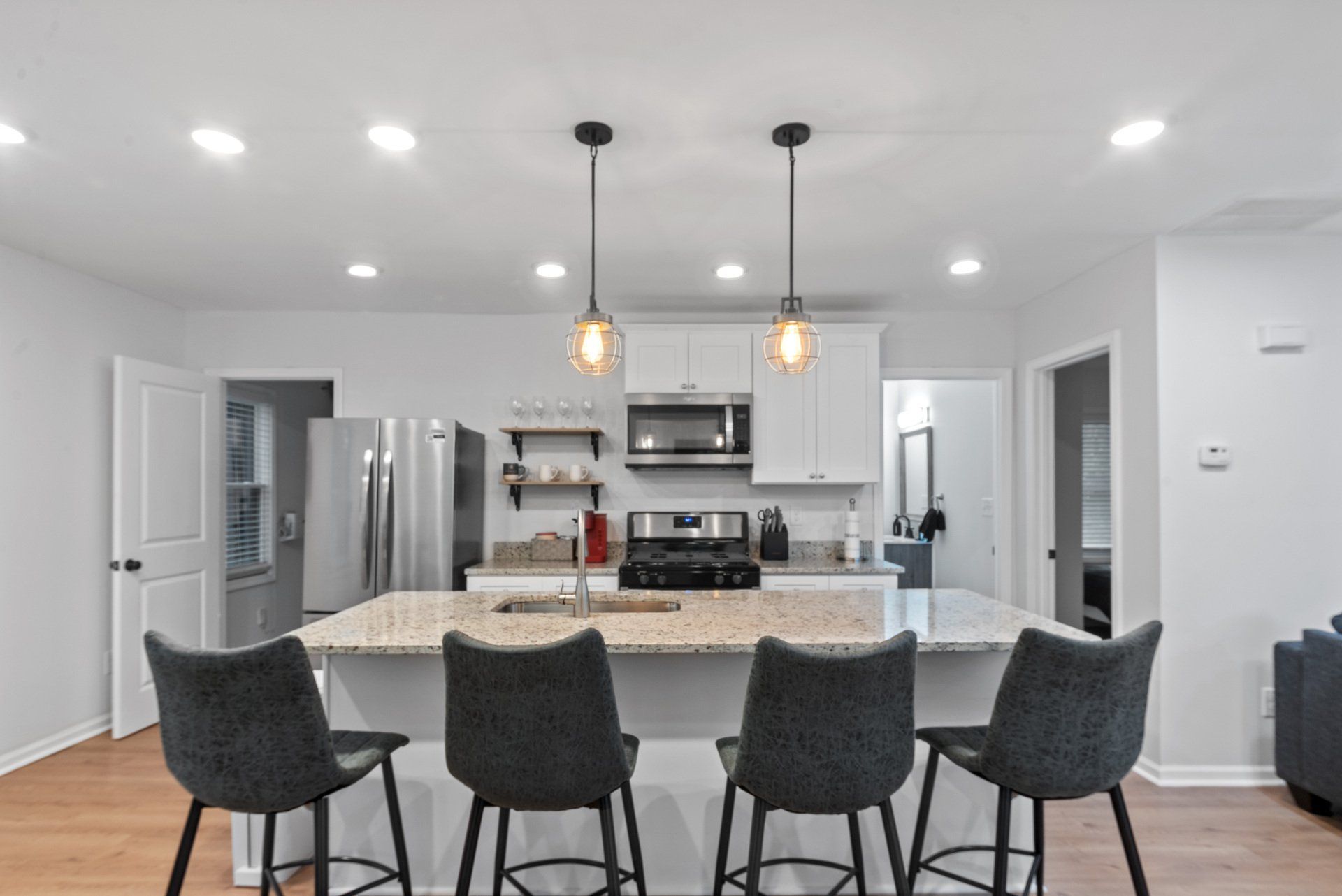 A kitchen with a large island and four chairs