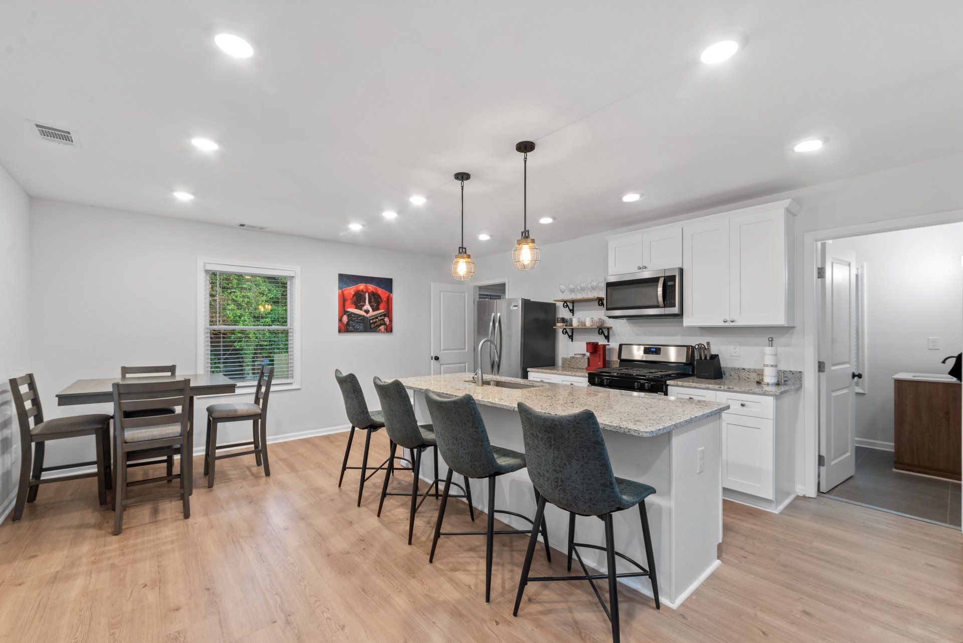 A kitchen with a large island and a dining table and chairs