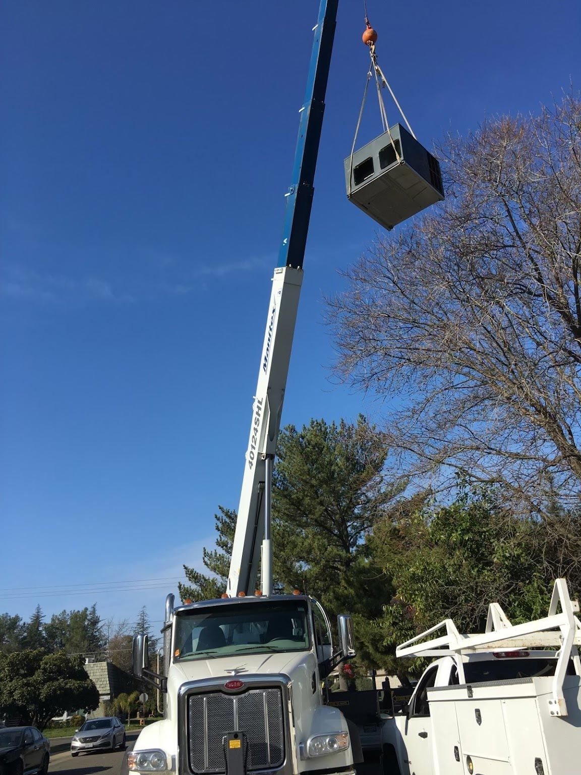 A Crane is Lifting a Box — Stockton, CA — Guerrero's Heating & Air Conditioning