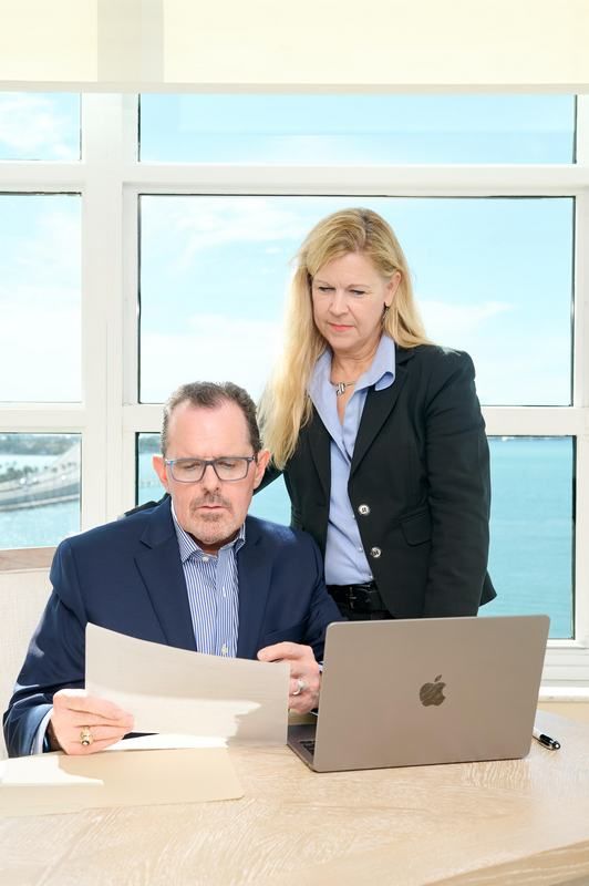 Todd Recknagel and Kristi Mailloux are standing next to each other at a desk with a laptop.