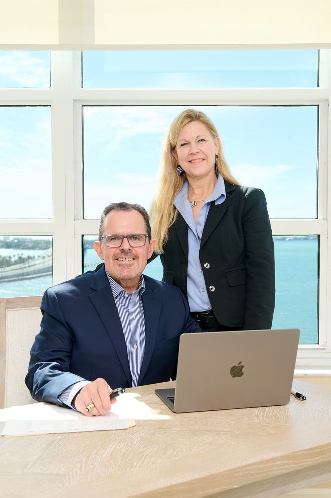 Todd Recknagel & Kristi Mailloux are standing next to each other in front of a laptop computer.