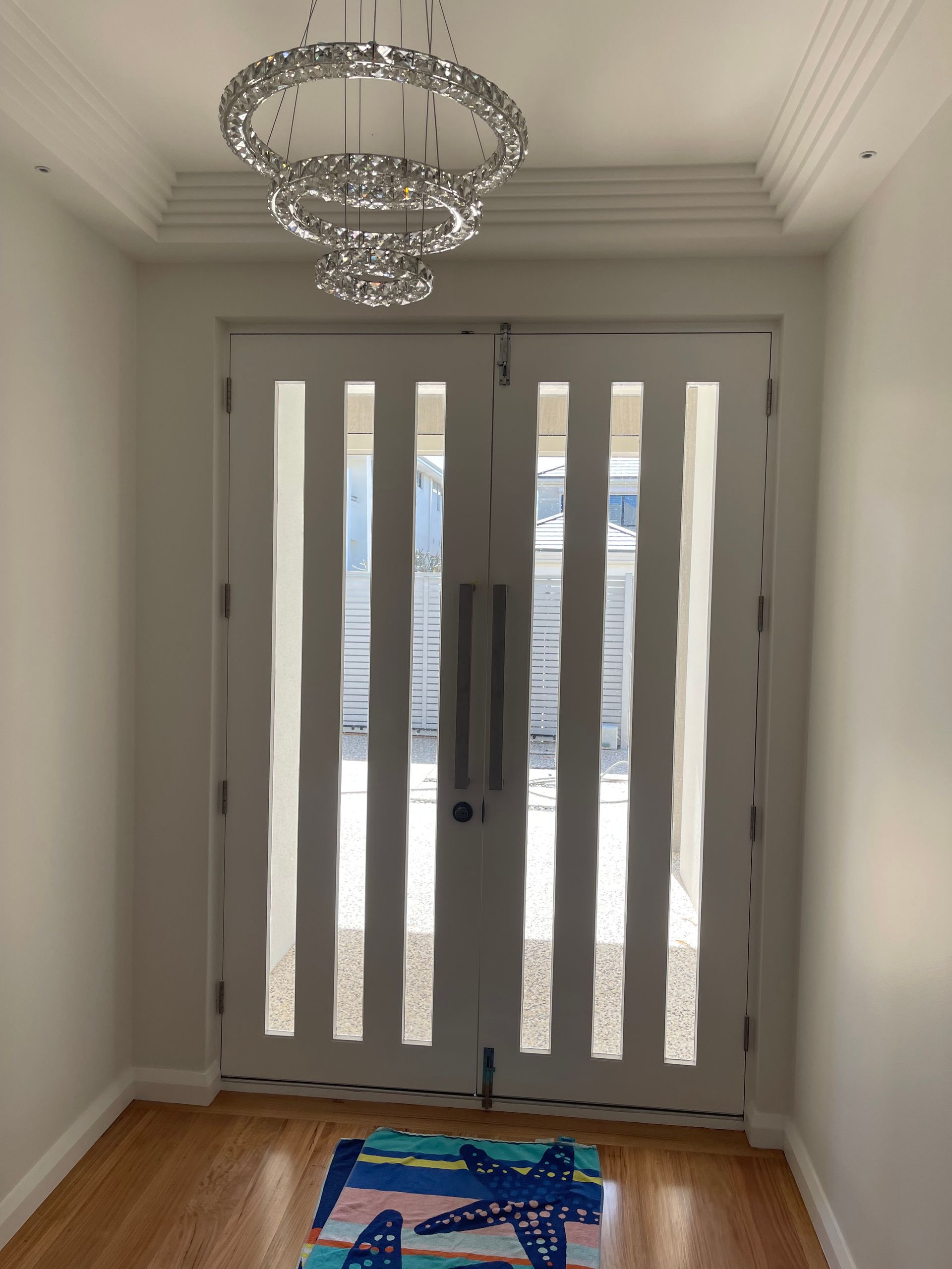 There is a chandelier hanging from the ceiling above the door.