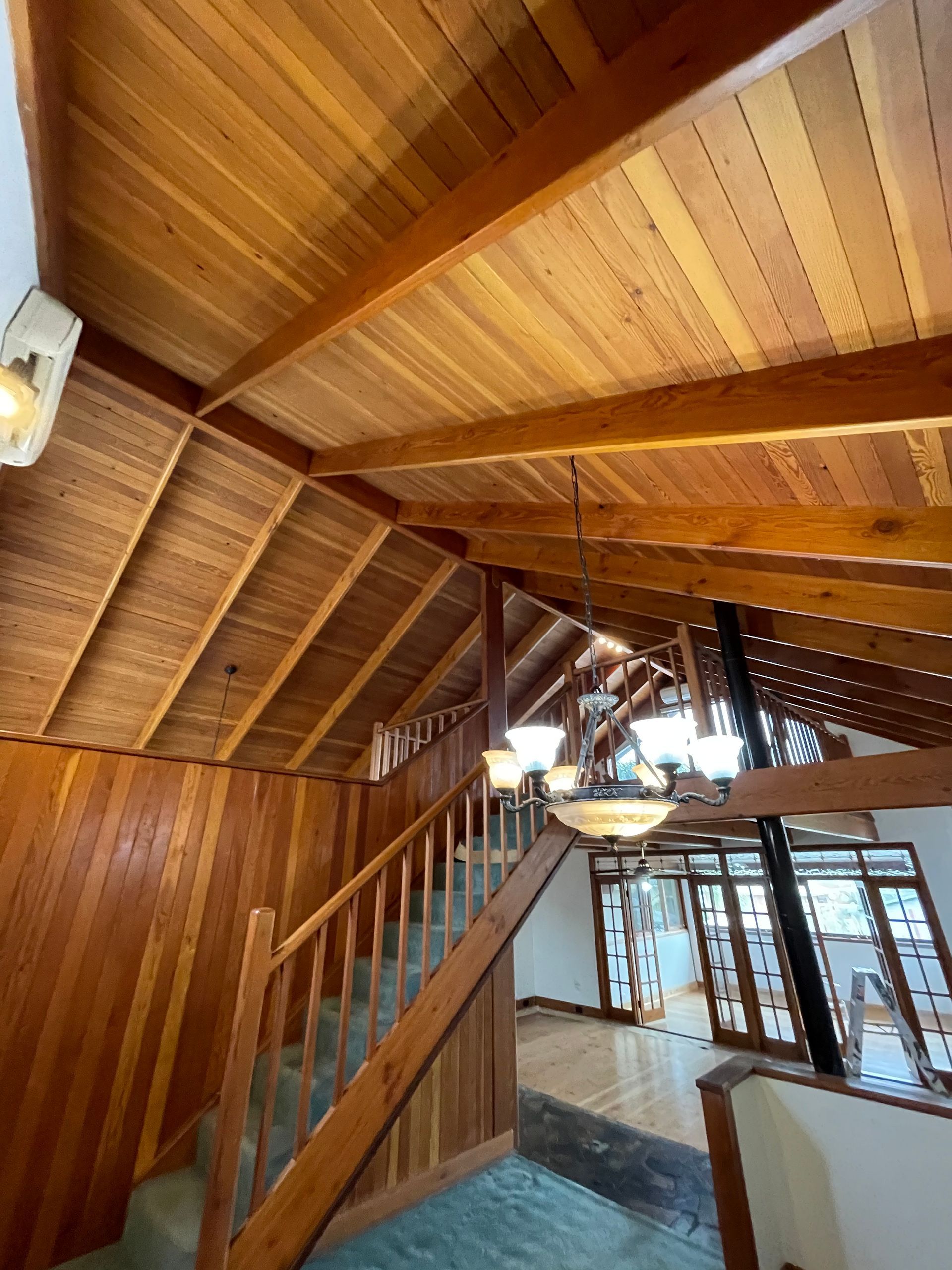 A wooden staircase in a house with a wooden ceiling
