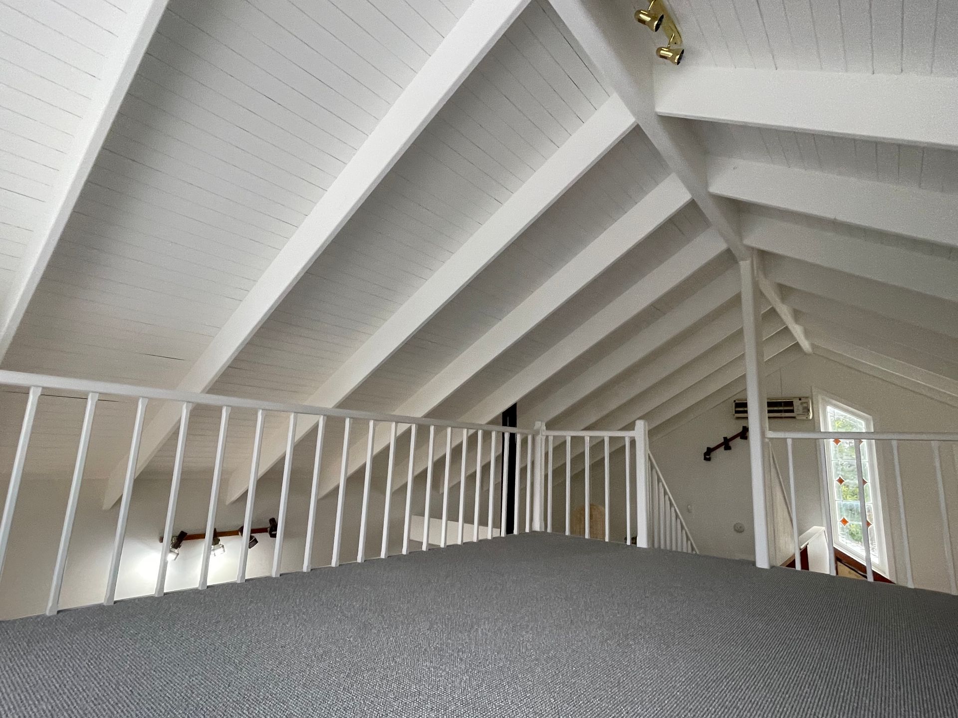 An attic with a white railing and stairs