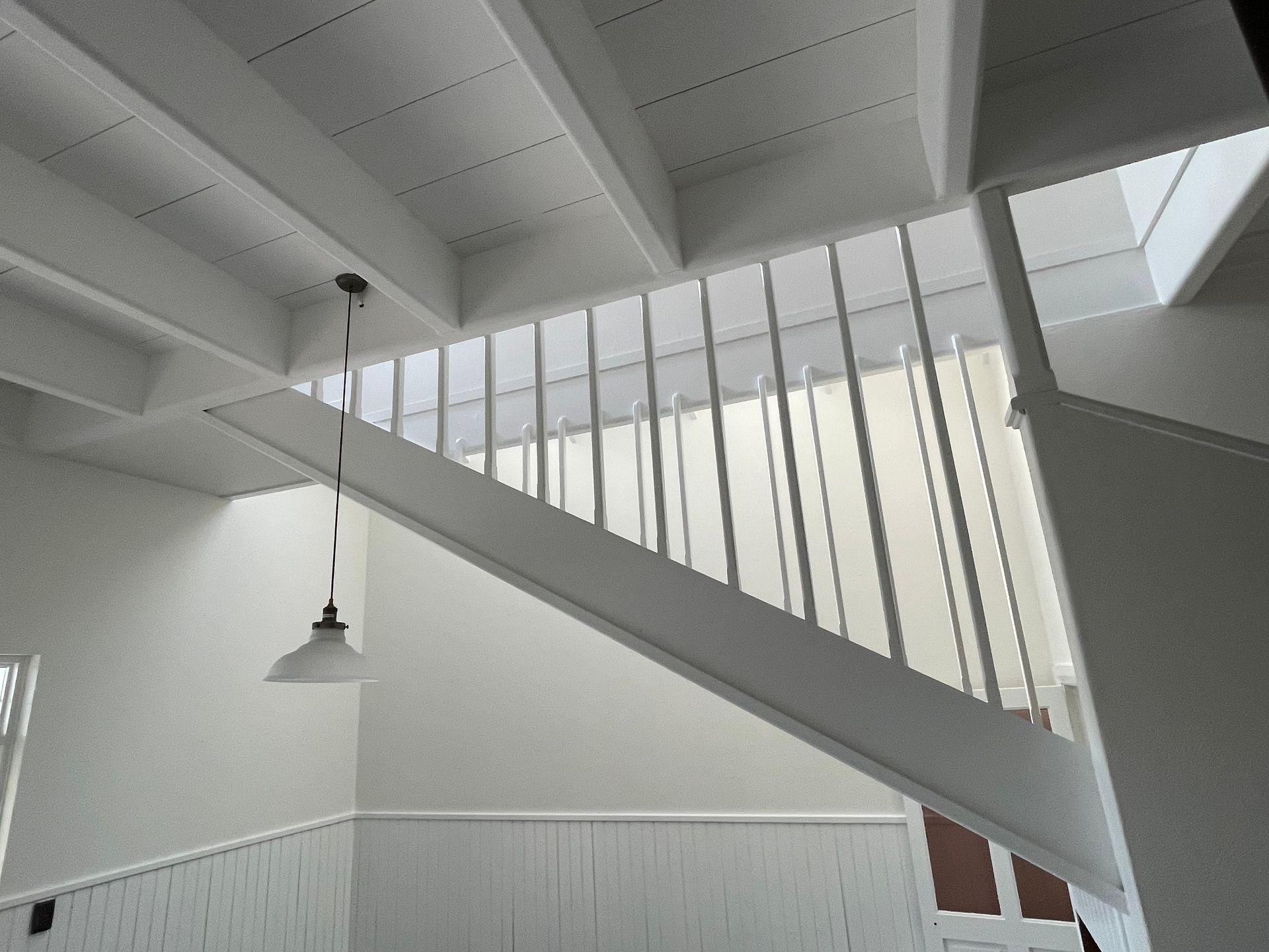 Looking up at a staircase with a light hanging from the ceiling