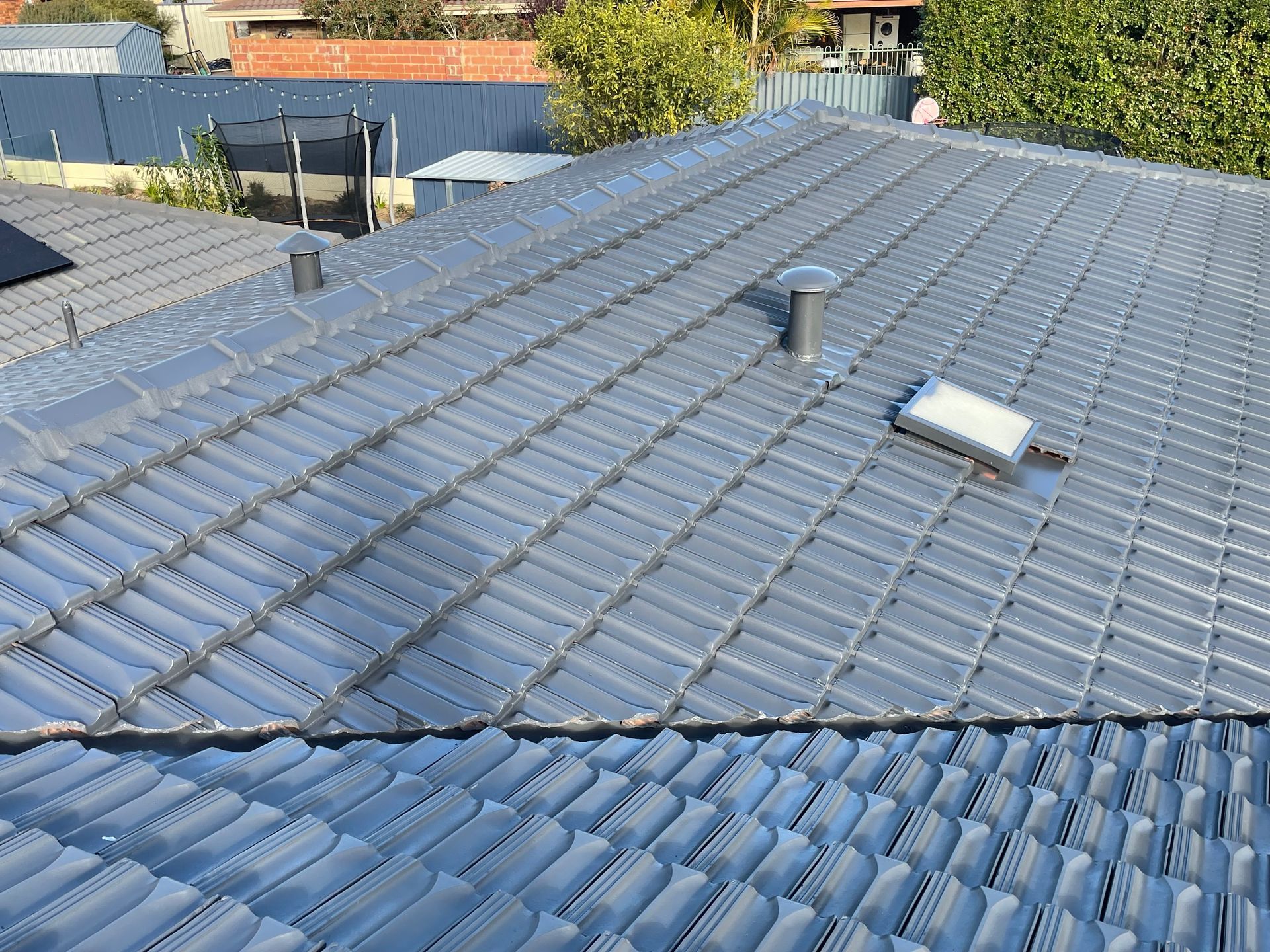The roof of a house has a skylight on it.