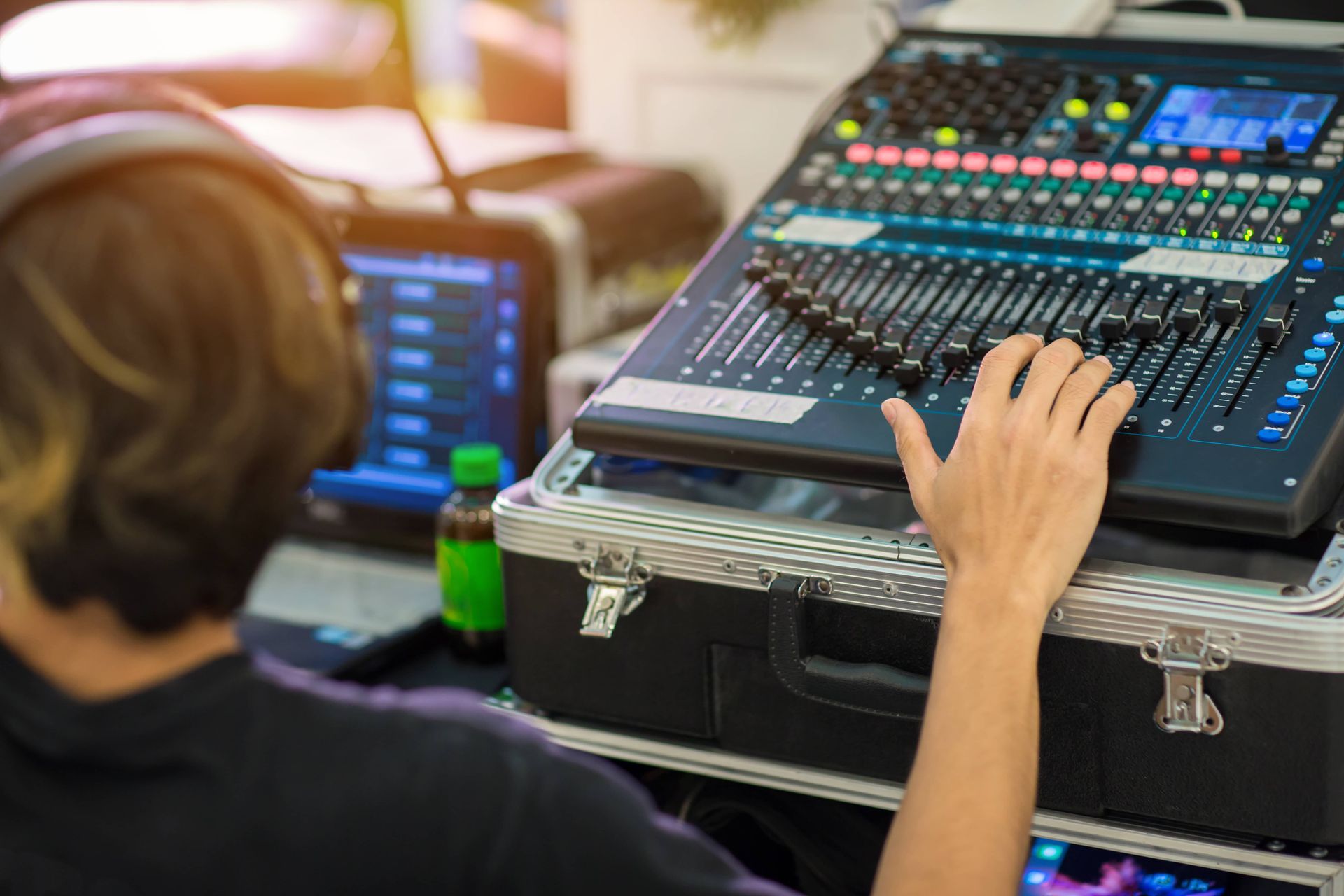 Person operating a digital audio mixing console at a live event